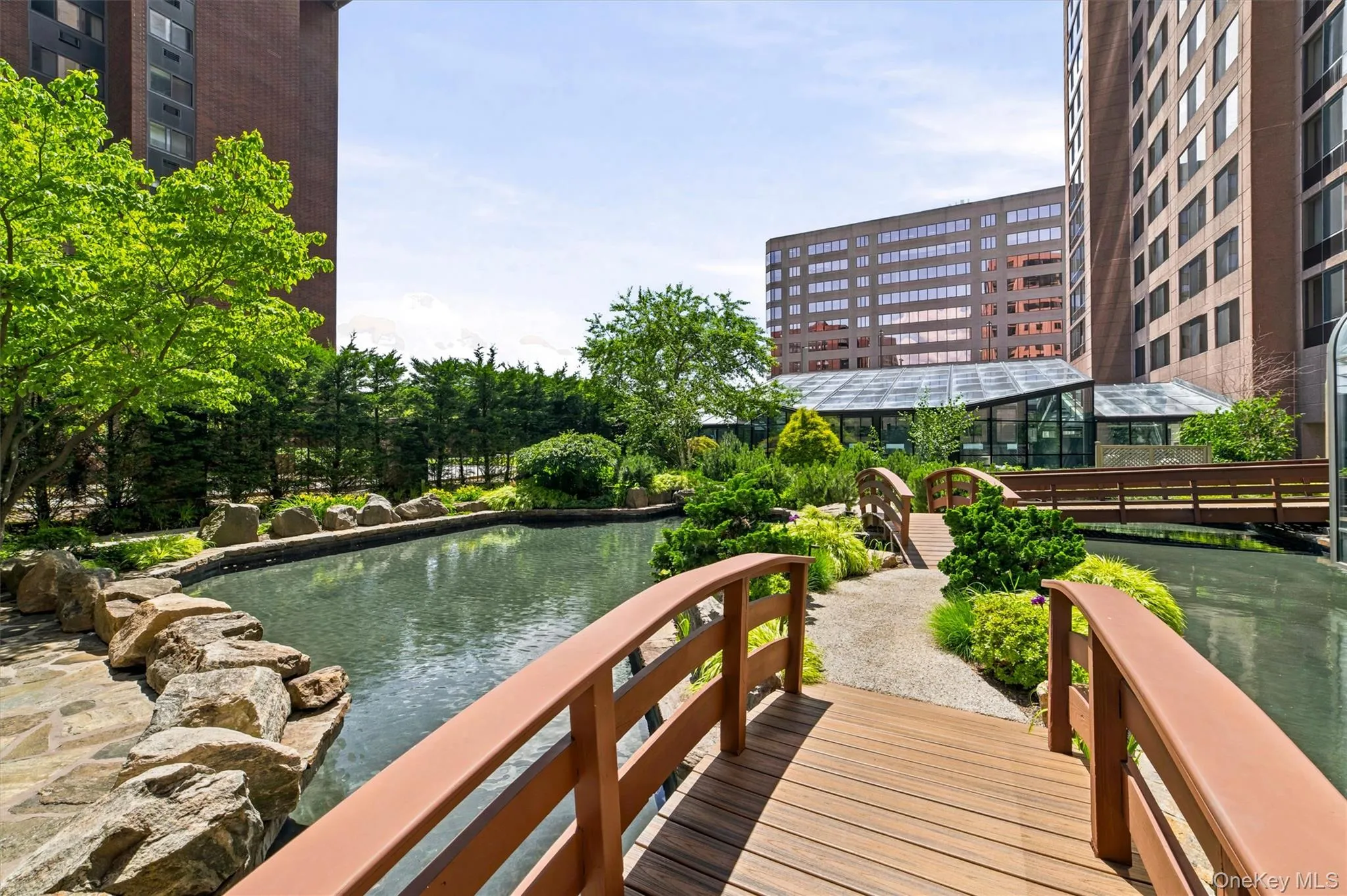 Serene courtyard setting with landscaped gardens, charming footbridge, patio space and barbecue area Serene courtyard setting with landscaped gardens, charming footbridge, patio space and barbecue area