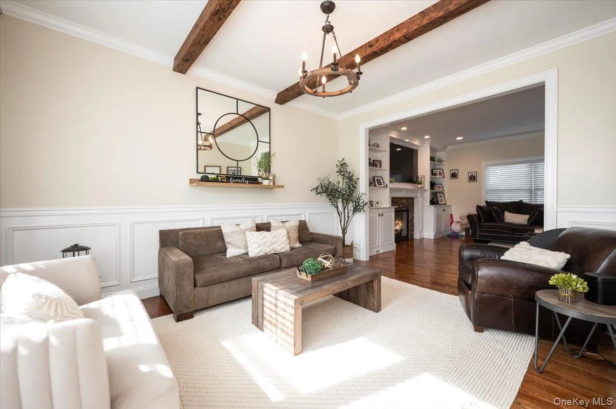 Living area featuring exposed ceiling beams and a chandelier Living area featuring exposed ceiling beams and a chandelier