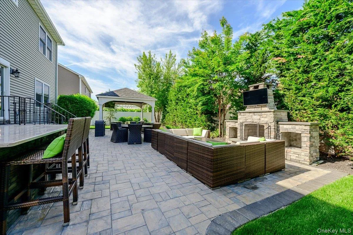 Expansive paver patio with a built-in stone fireplace and television enclosure Expansive paver patio with a built-in stone fireplace and television enclosure