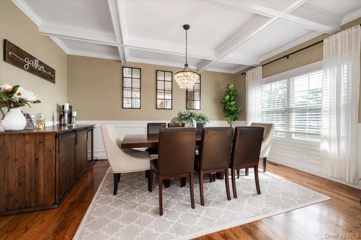 Coffered ceiling with a crystal chandelier over wood-finish flooring Coffered ceiling with a crystal chandelier over wood-finish flooring