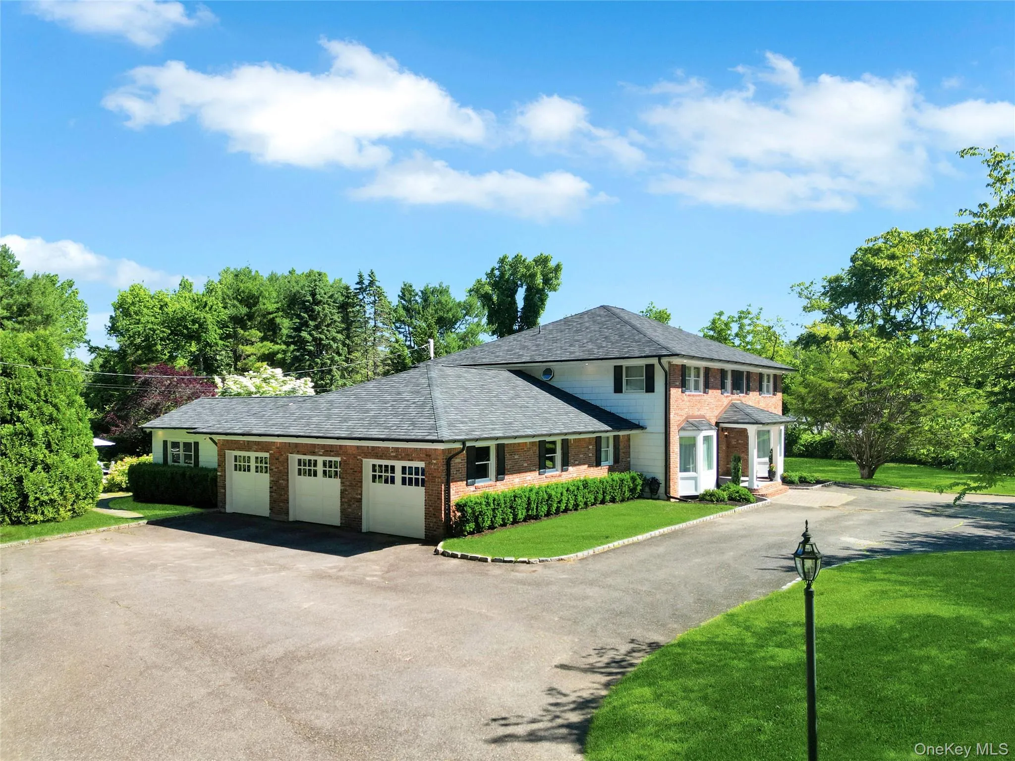 View of front of house featuring asphalt driveway, a garage, brick siding, and a front lawn View of front of house featuring asphalt driveway, a garage, brick siding, and a front lawn