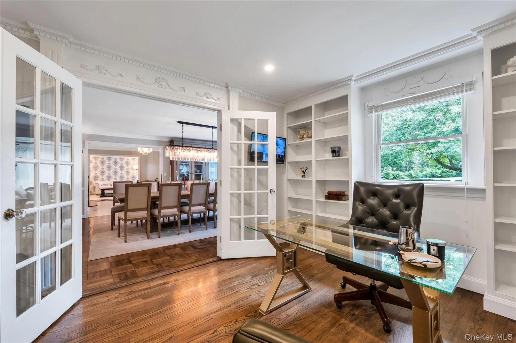 Office area featuring french doors, built in features, crown molding, and parquet flooring Office area featuring french doors, built in features, crown molding, and parquet flooring