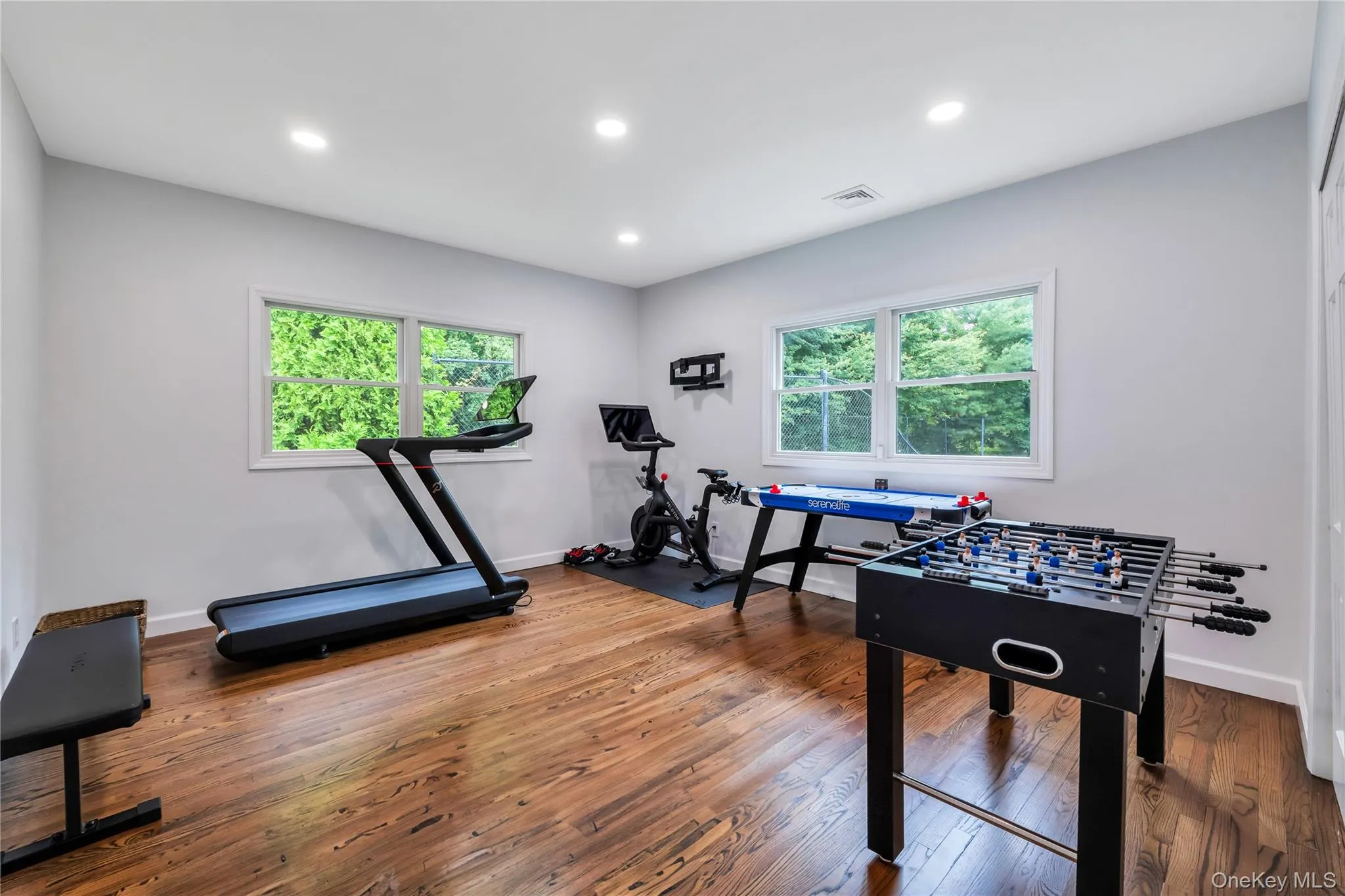 Recreation room featuring plenty of natural light, hardwood / wood-style flooring, recessed lighting, and baseboards Recreation room featuring plenty of natural light, hardwood / wood-style flooring, recessed lighting, and baseboards