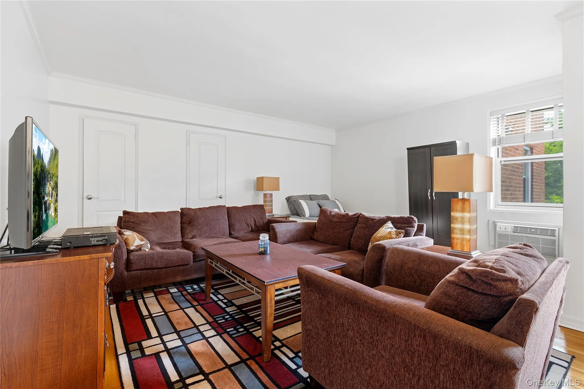 Open-concept living area featuring light wood-finish flooring and bright white walls Open-concept living area featuring light wood-finish flooring and bright white walls