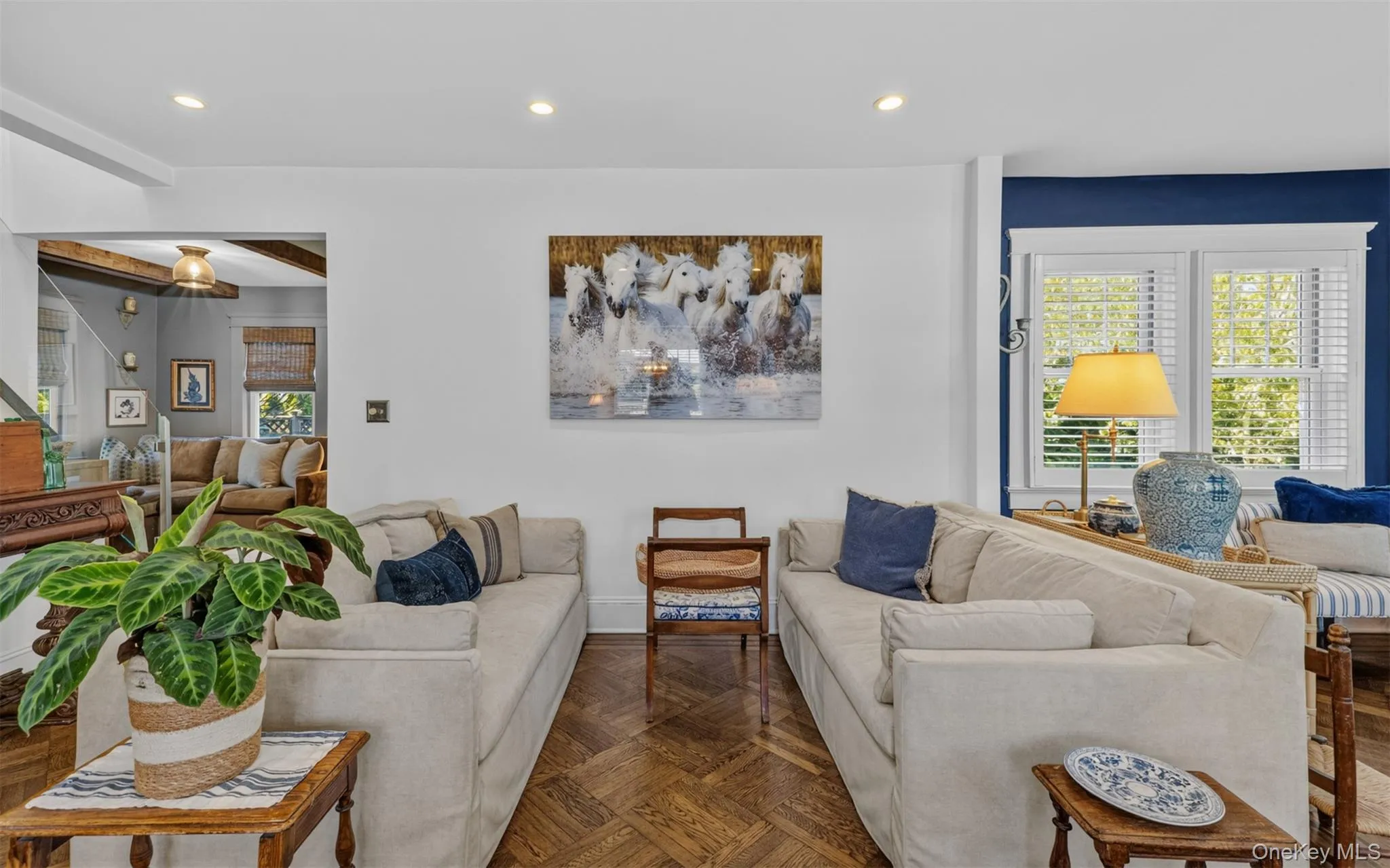 Living area featuring hardwood- flooring in a herringbone pattern, recessed lighting, and white walls Living area featuring hardwood- flooring in a herringbone pattern, recessed lighting, and white walls