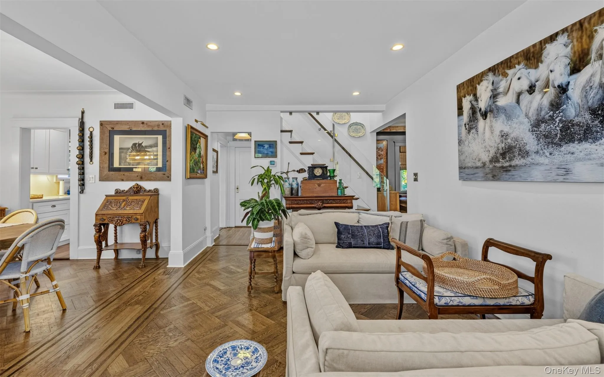 Living area featuring hardwood- flooring in a herringbone pattern, recessed lighting, and white walls Living area featuring hardwood- flooring in a herringbone pattern, recessed lighting, and white walls