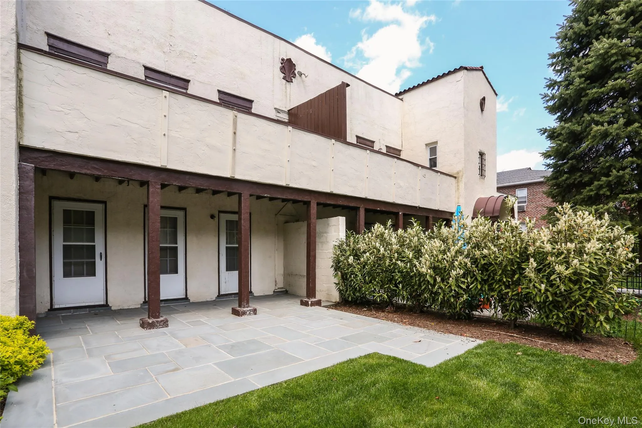 Back of house featuring stucco siding, a patio, and a yard Back of house featuring stucco siding, a patio, and a yard