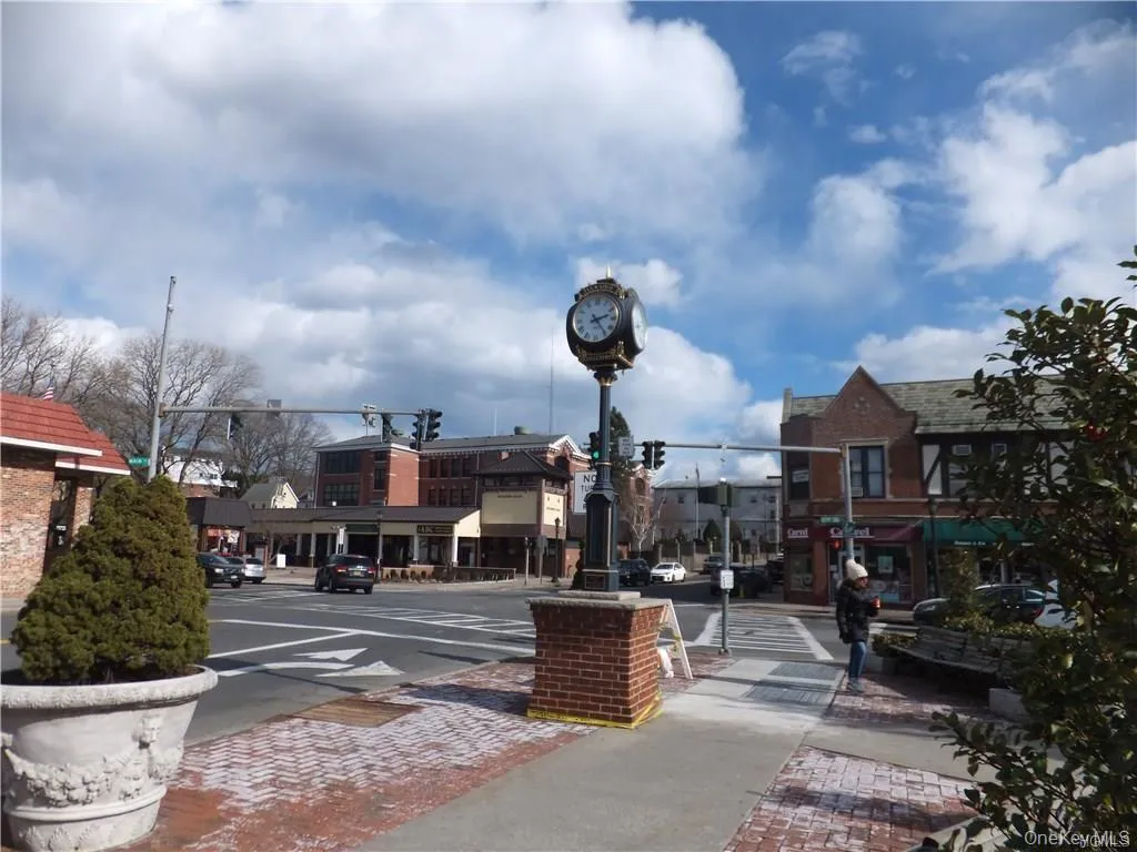 View of asphalt road with sidewalks, traffic lights, curbs, and street lighting View of asphalt road with sidewalks, traffic lights, curbs, and street lighting