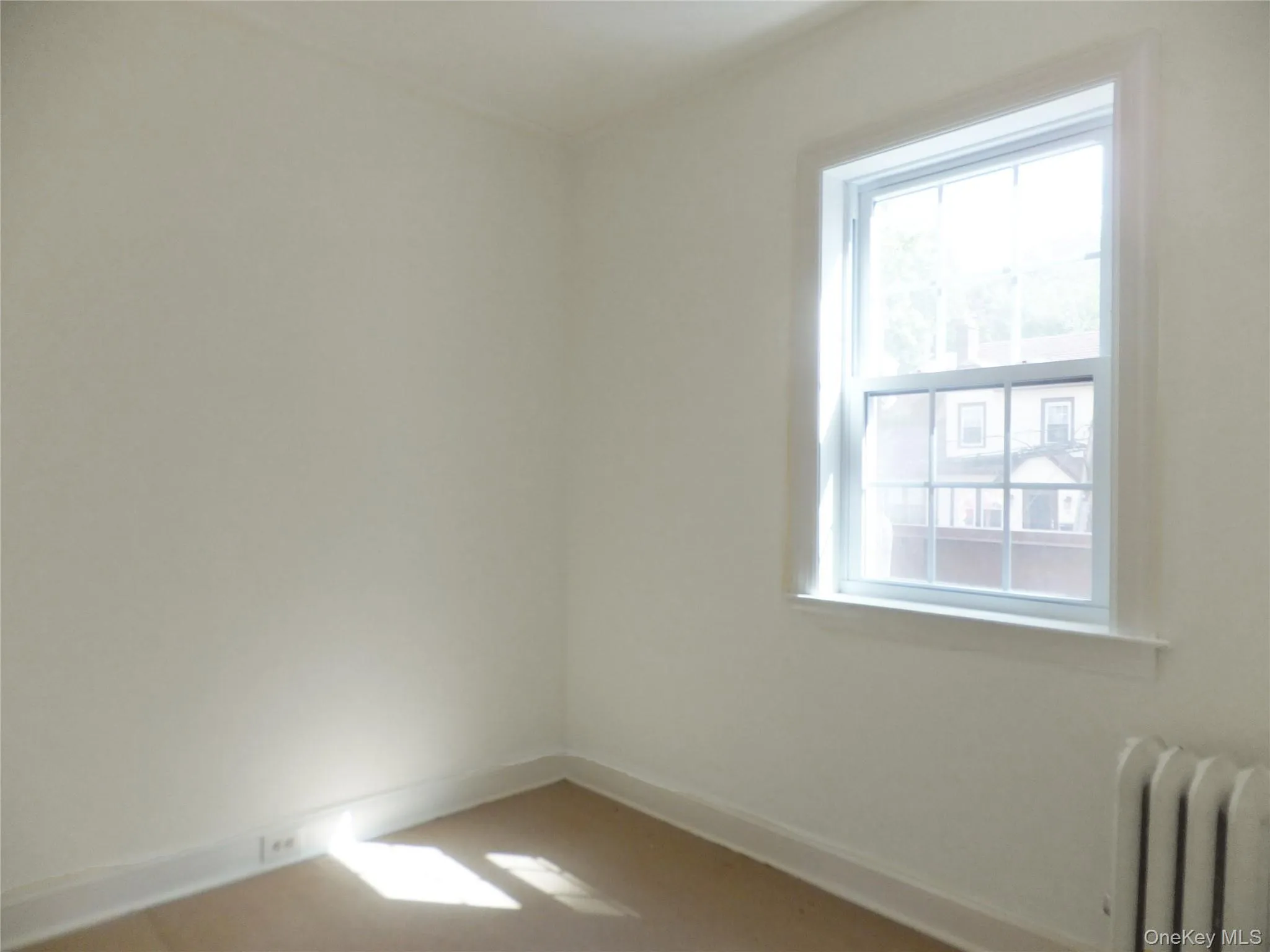 Spare room featuring radiator and baseboards Spare room featuring radiator and baseboards