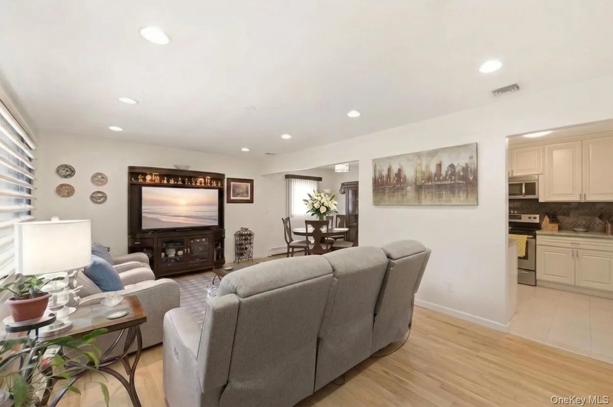 Open-concept living area featuring light natural wood flooring, recessed lighting, and beautiful flow to the kitchen and dining areas. Open-concept living area featuring light natural wood flooring, recessed lighting, and beautiful flow to the kitchen and dining areas.