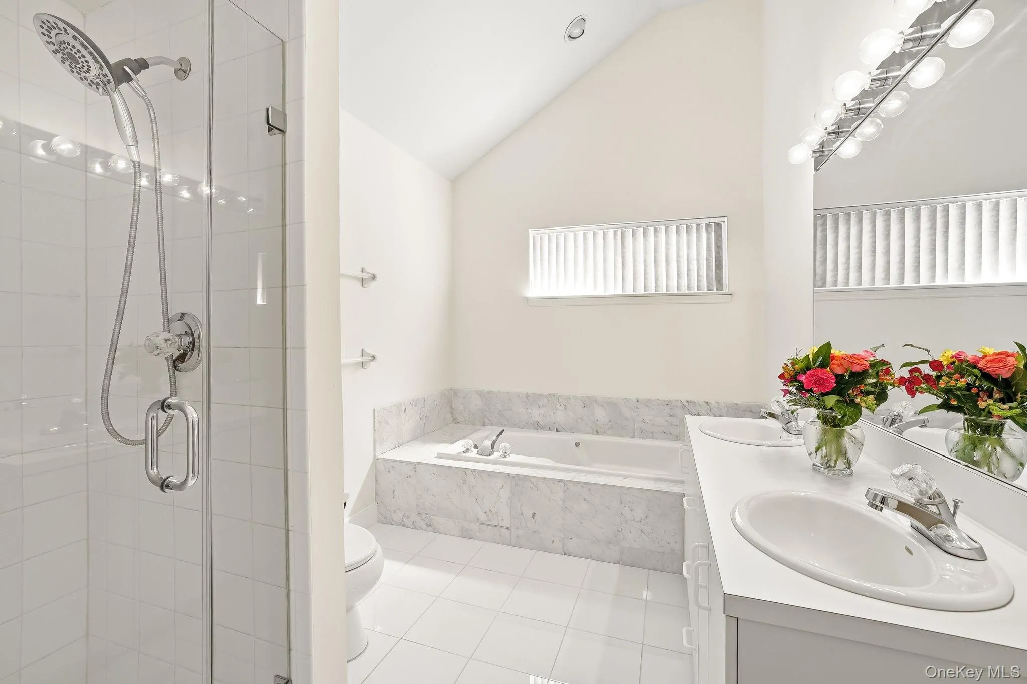 The primary bedroom with high ceiling has a double-sink vanity and glass front shower stall The primary bedroom with high ceiling has a double-sink vanity and glass front shower stall