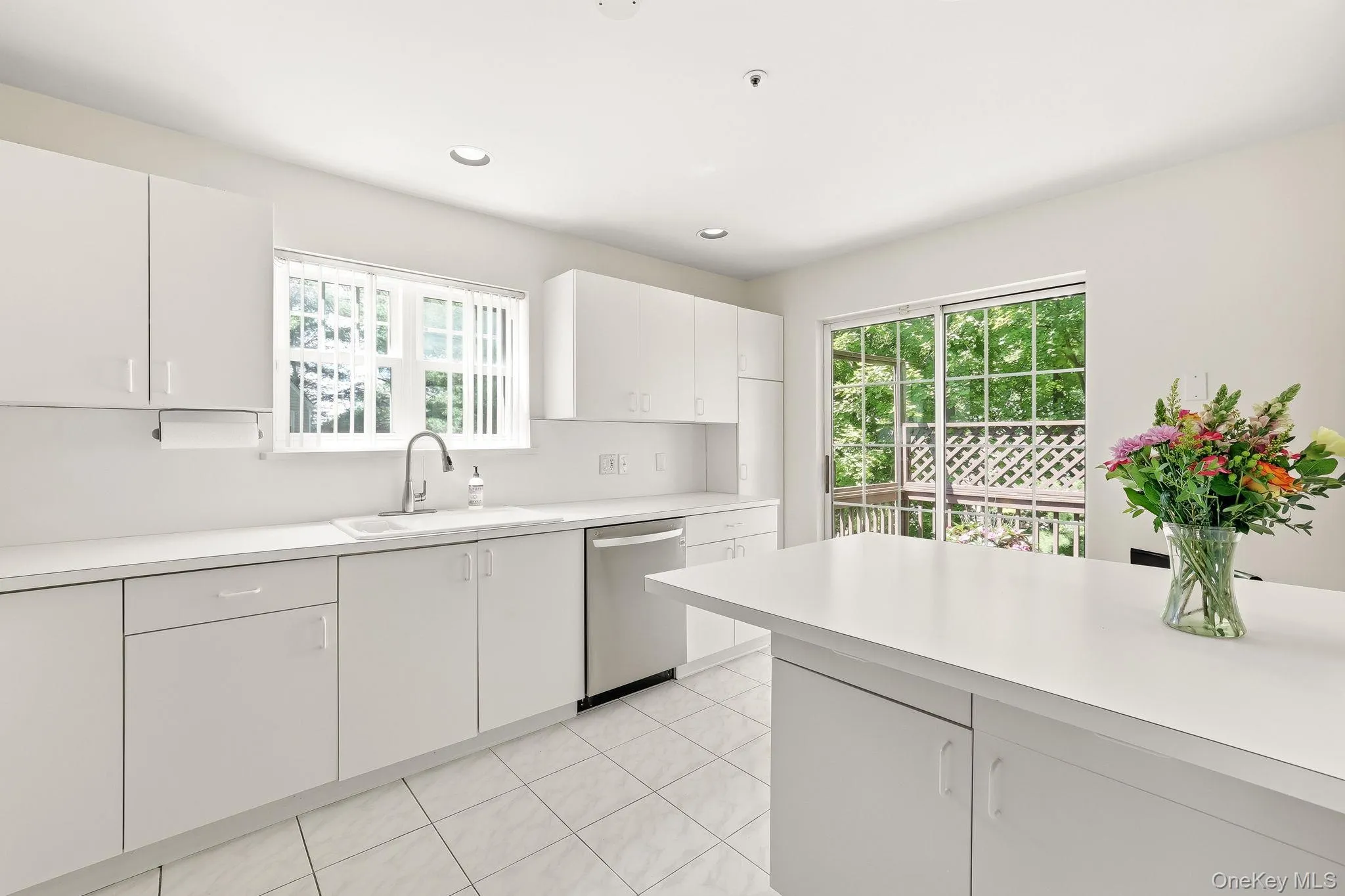 Classic white-on-white kitchen with the sliding glass doors to a long 18-foot raised deck invites alfesco relaxing and dining Classic white-on-white kitchen with the sliding glass doors to a long 18-foot raised deck invites alfesco relaxing and dining