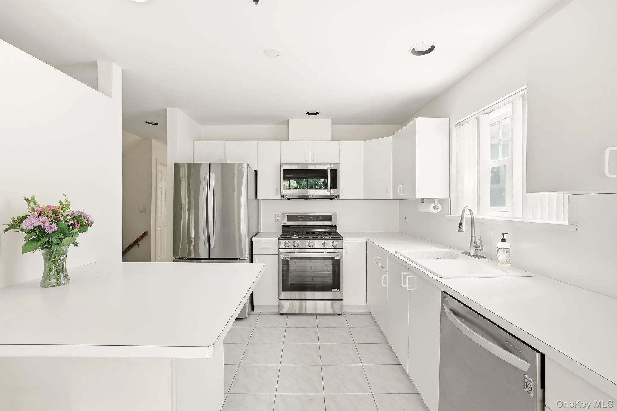 The kitchen has stainless steel appliances and recessed lighting. with a south-facing window The kitchen has stainless steel appliances and recessed lighting. with a south-facing window