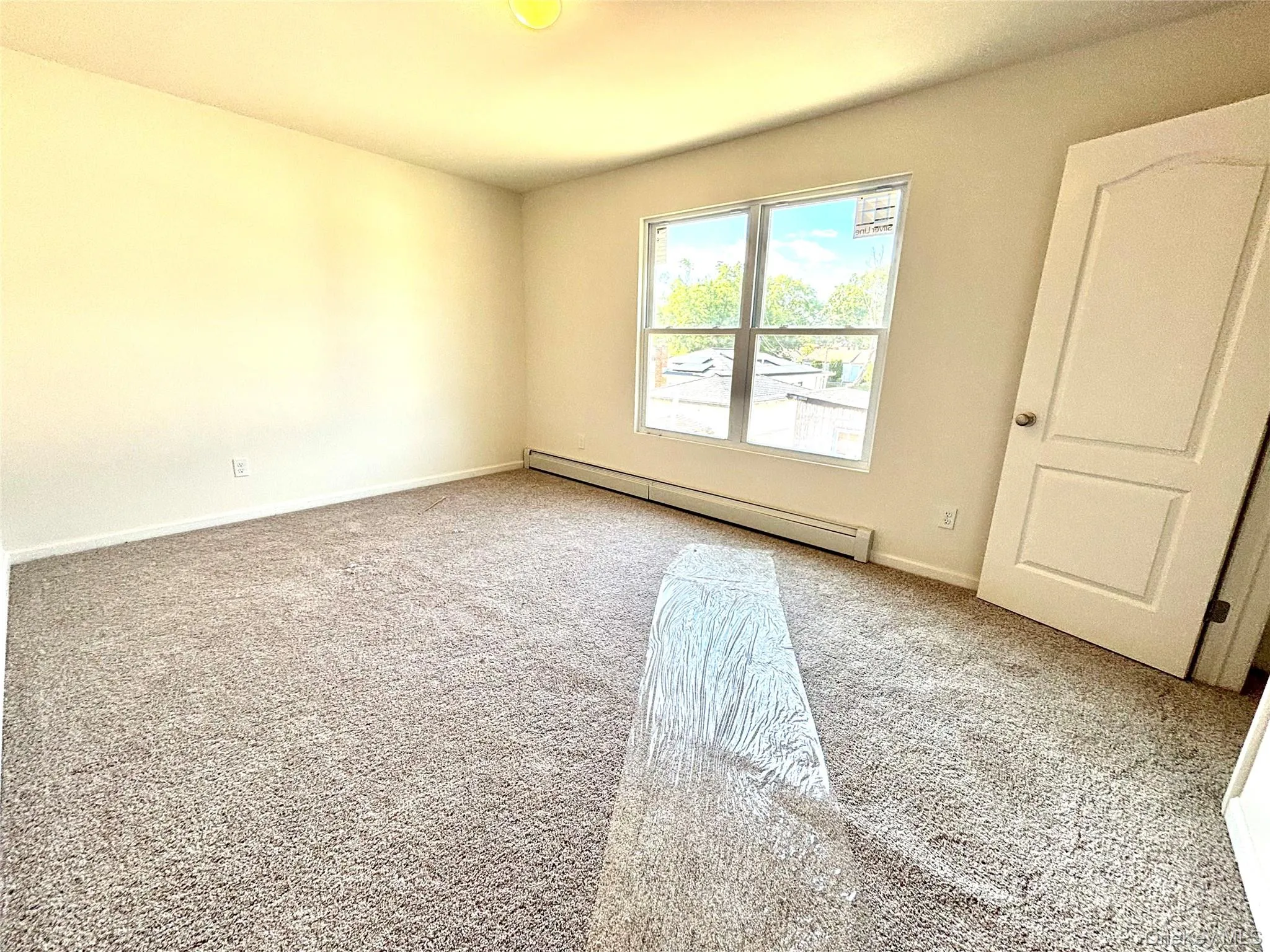 Spacious room featuring neutral carpeting and light-toned walls Spacious room featuring neutral carpeting and light-toned walls