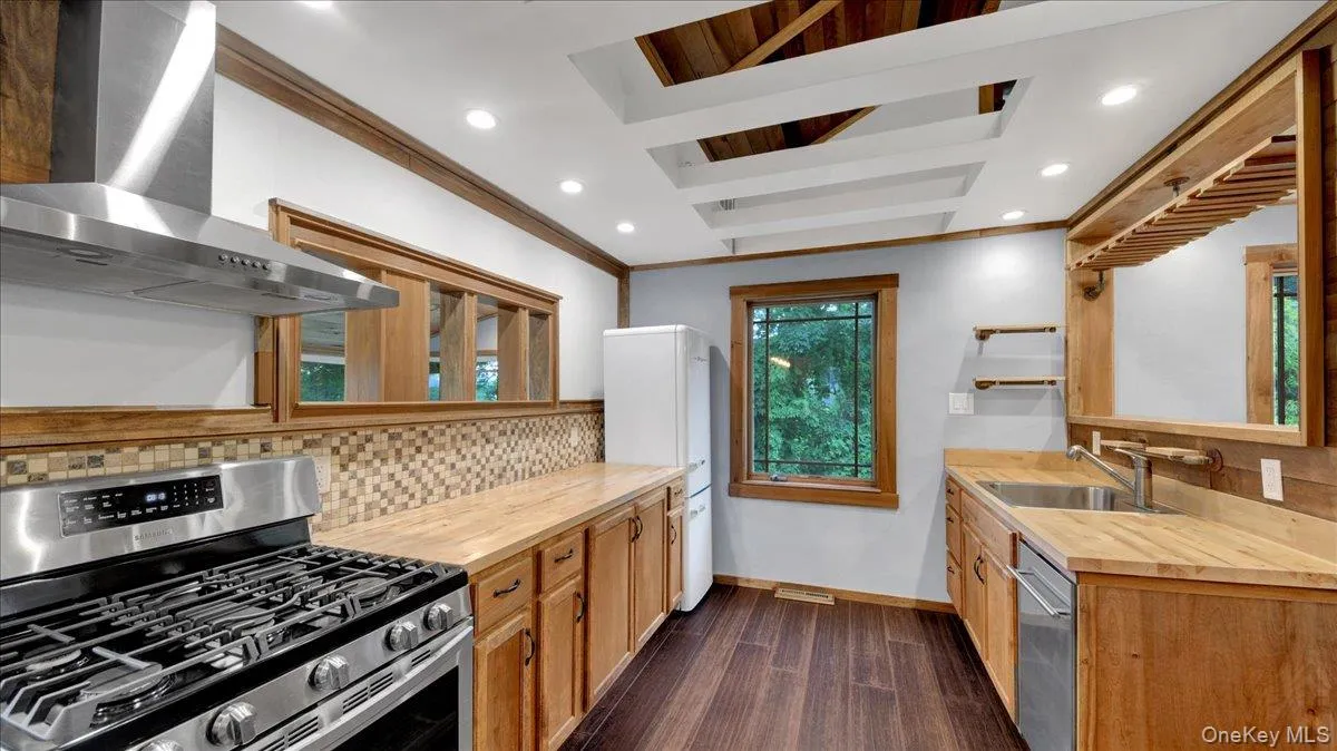 Contemporary kitchen featuring wood-finish flooring, light wood cabinetry, and solid wood countertops Contemporary kitchen featuring wood-finish flooring, light wood cabinetry, and solid wood countertops