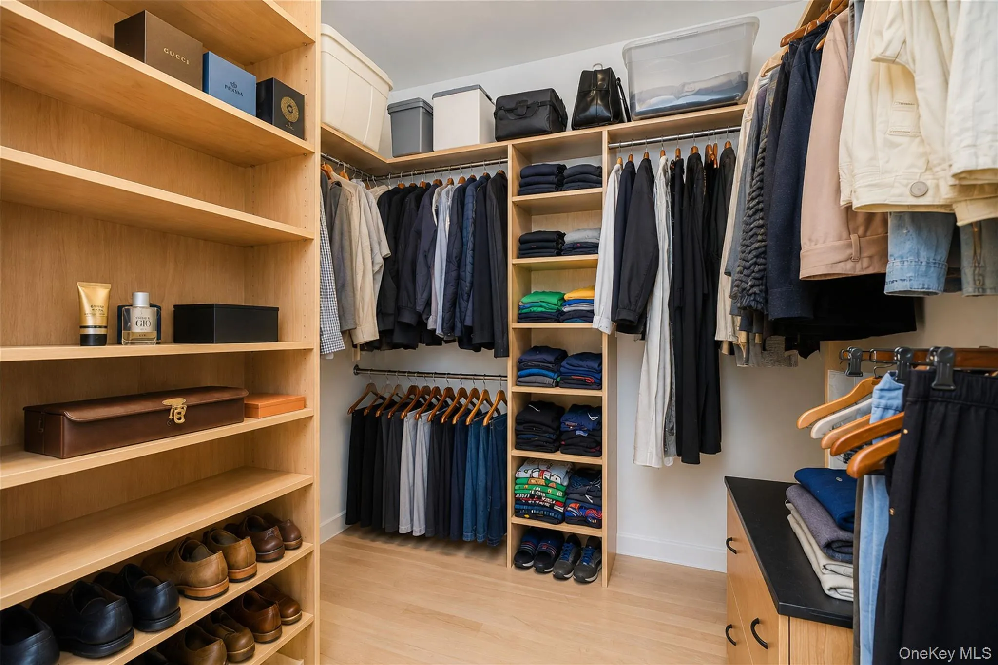 Custom closet system featuring light wood-finish shelving and extensive hanging storage Custom closet system featuring light wood-finish shelving and extensive hanging storage