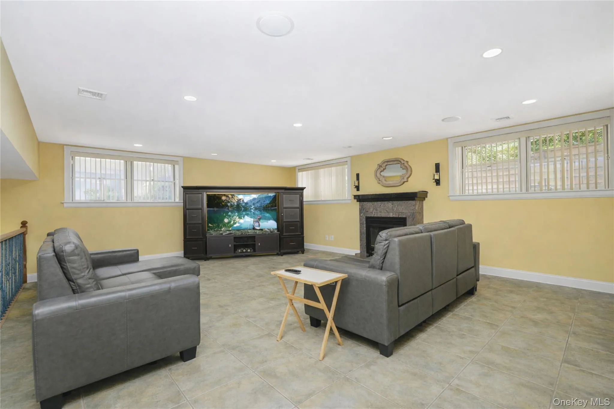 Spacious finished area featuring recessed lighting, tile flooring, and multiple windows Spacious finished area featuring recessed lighting, tile flooring, and multiple windows