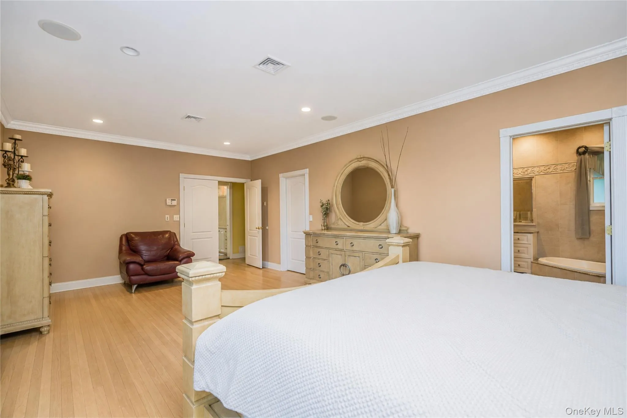 Bedroom featuring light wood-finish flooring, recessed lighting, and crown molding Bedroom featuring light wood-finish flooring, recessed lighting, and crown molding