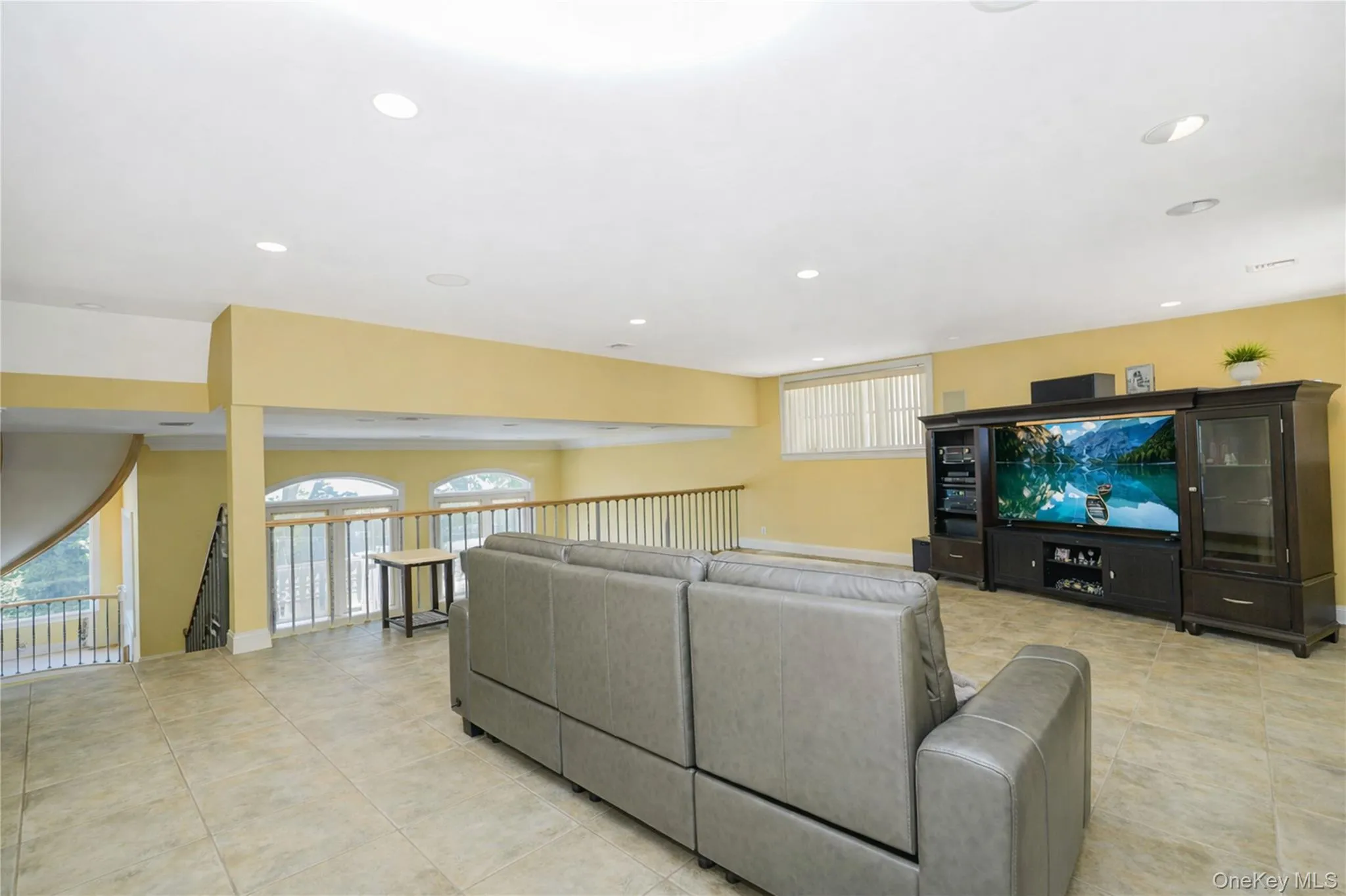 Spacious loft area featuring recessed lighting, tile flooring, and a media wall with built-in cabinetry Spacious loft area featuring recessed lighting, tile flooring, and a media wall with built-in cabinetry