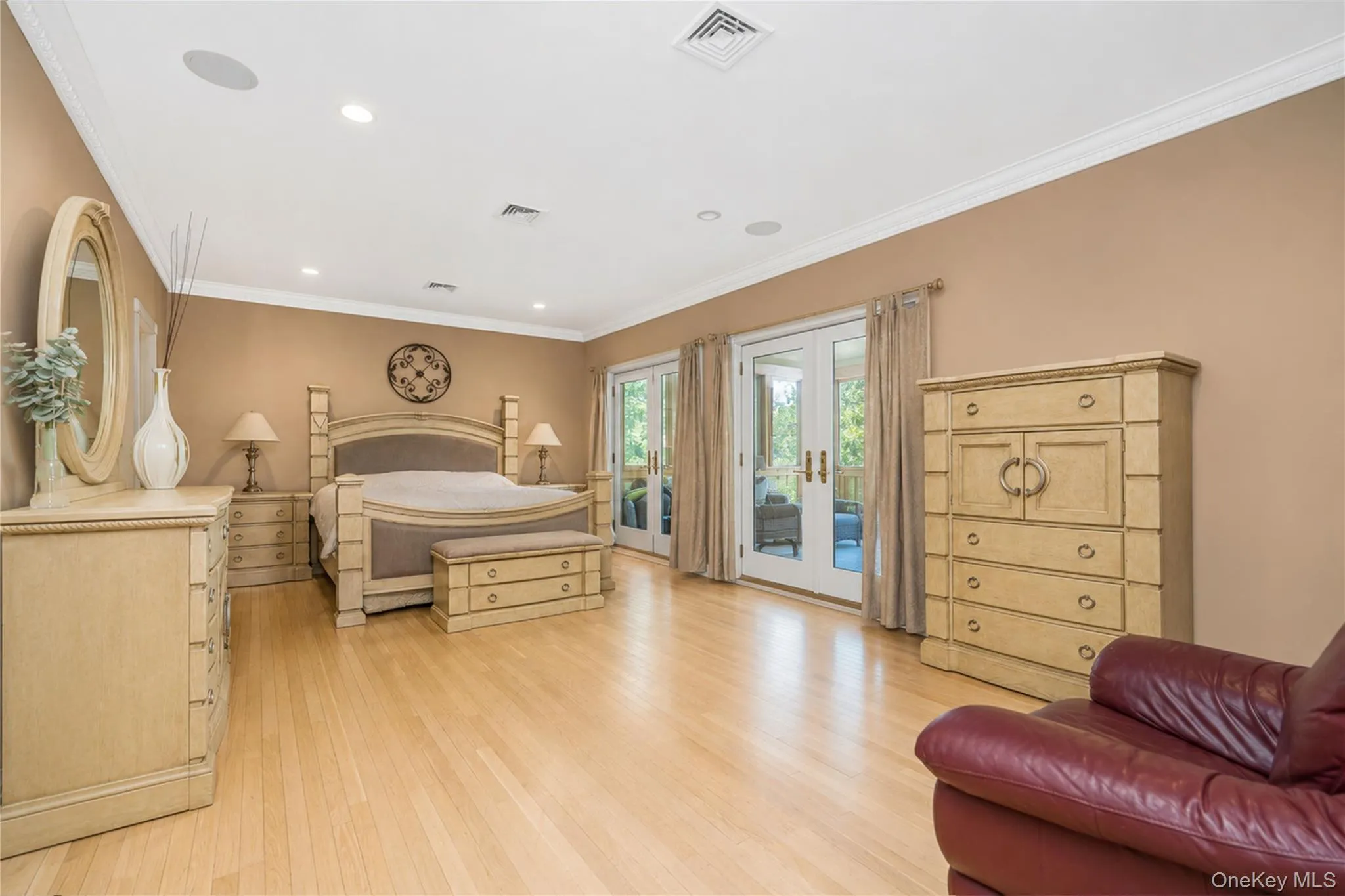 Spacious room featuring light wood-finish flooring and crown molding Spacious room featuring light wood-finish flooring and crown molding
