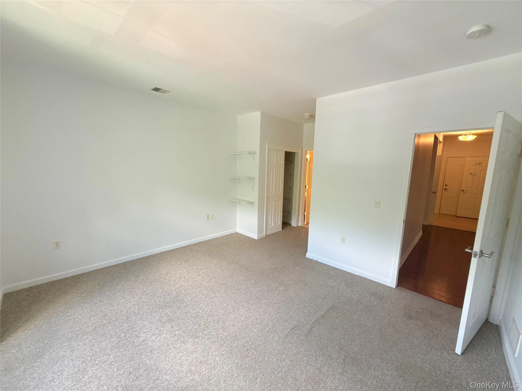Carpeted room featuring light neutral walls and baseboards Carpeted room featuring light neutral walls and baseboards