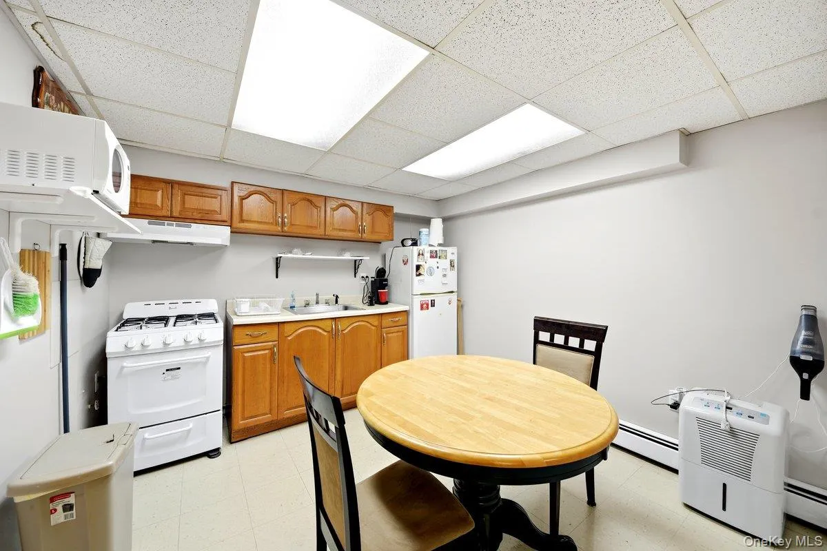 Kitchenette featuring wood cabinetry, a gas range, a sink with a countertop Kitchenette featuring wood cabinetry, a gas range, a sink with a countertop