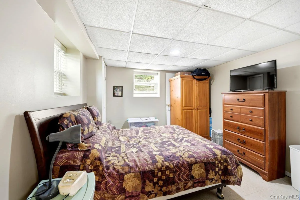 Lower-level room featuring light-toned walls, & two windows Lower-level room featuring light-toned walls, & two windows