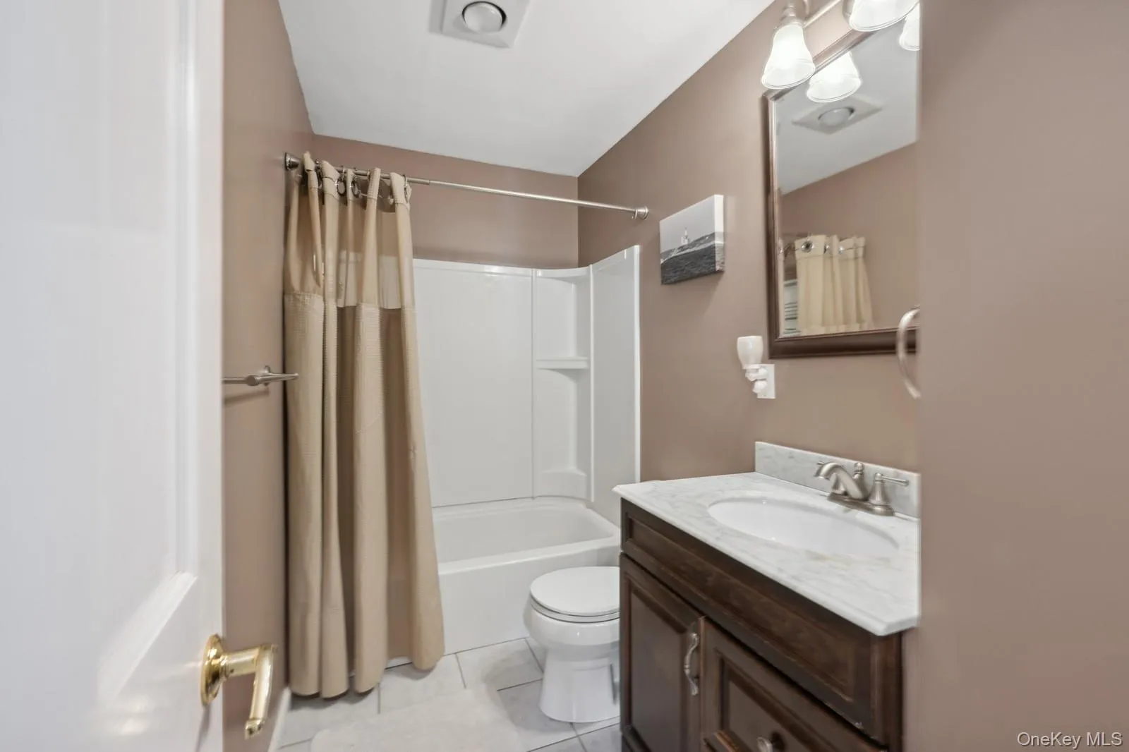 Full bathroom featuring tile patterned floors, vanity, toilet, and shower / tub combo Full bathroom featuring tile patterned floors, vanity, toilet, and shower / tub combo