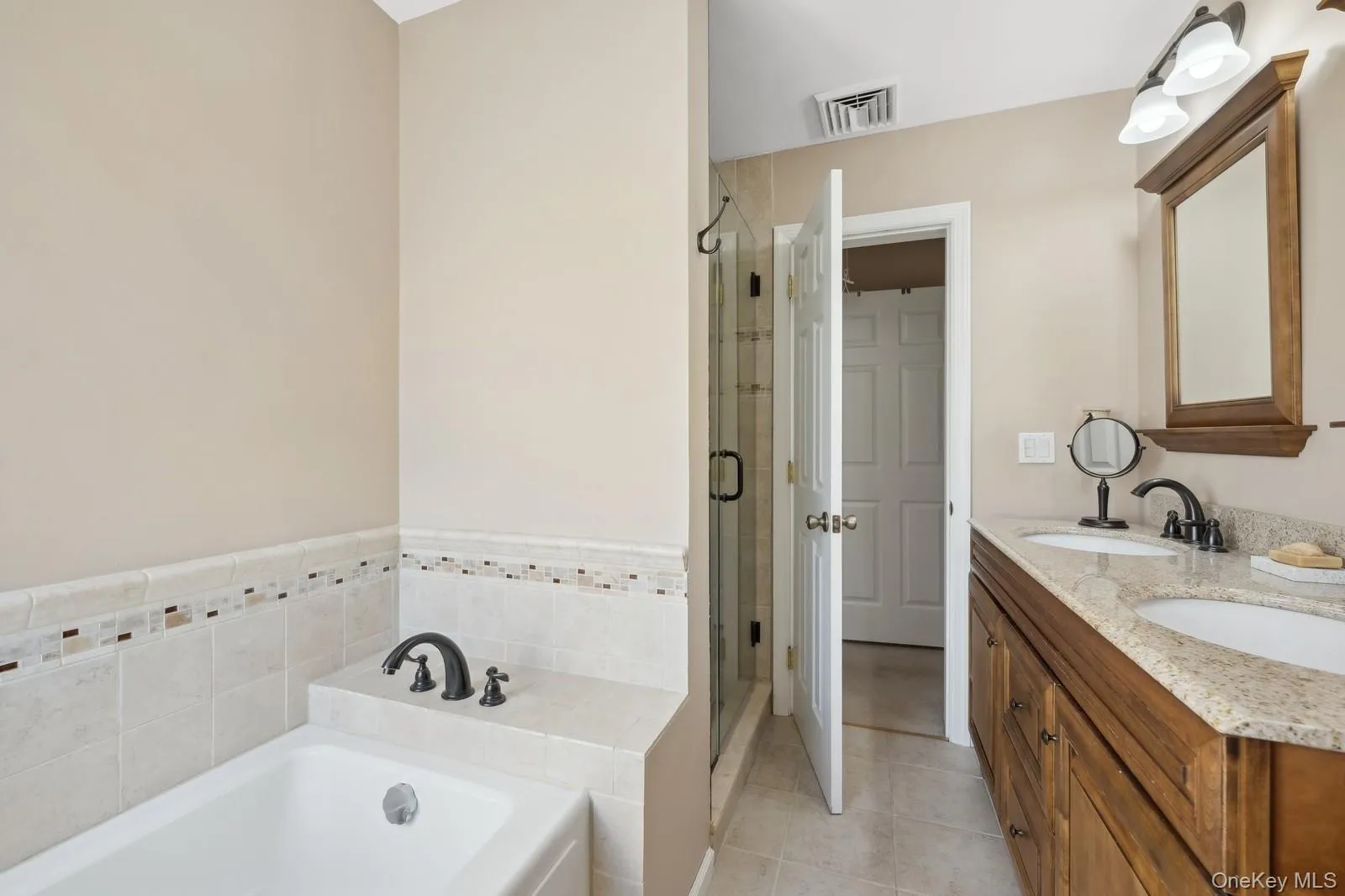 Bathroom featuring vanity, tile patterned flooring, and plus walk in shower Bathroom featuring vanity, tile patterned flooring, and plus walk in shower