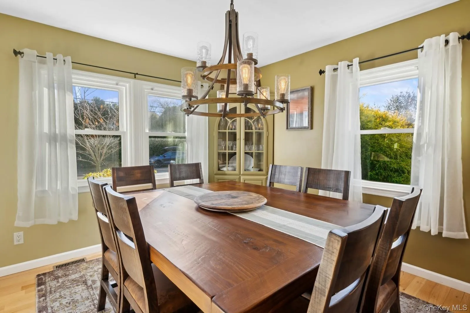 Dining area featuring a wealth of natural light, a chandelier, and hardwood / wood-style flooring Dining area featuring a wealth of natural light, a chandelier, and hardwood / wood-style flooring