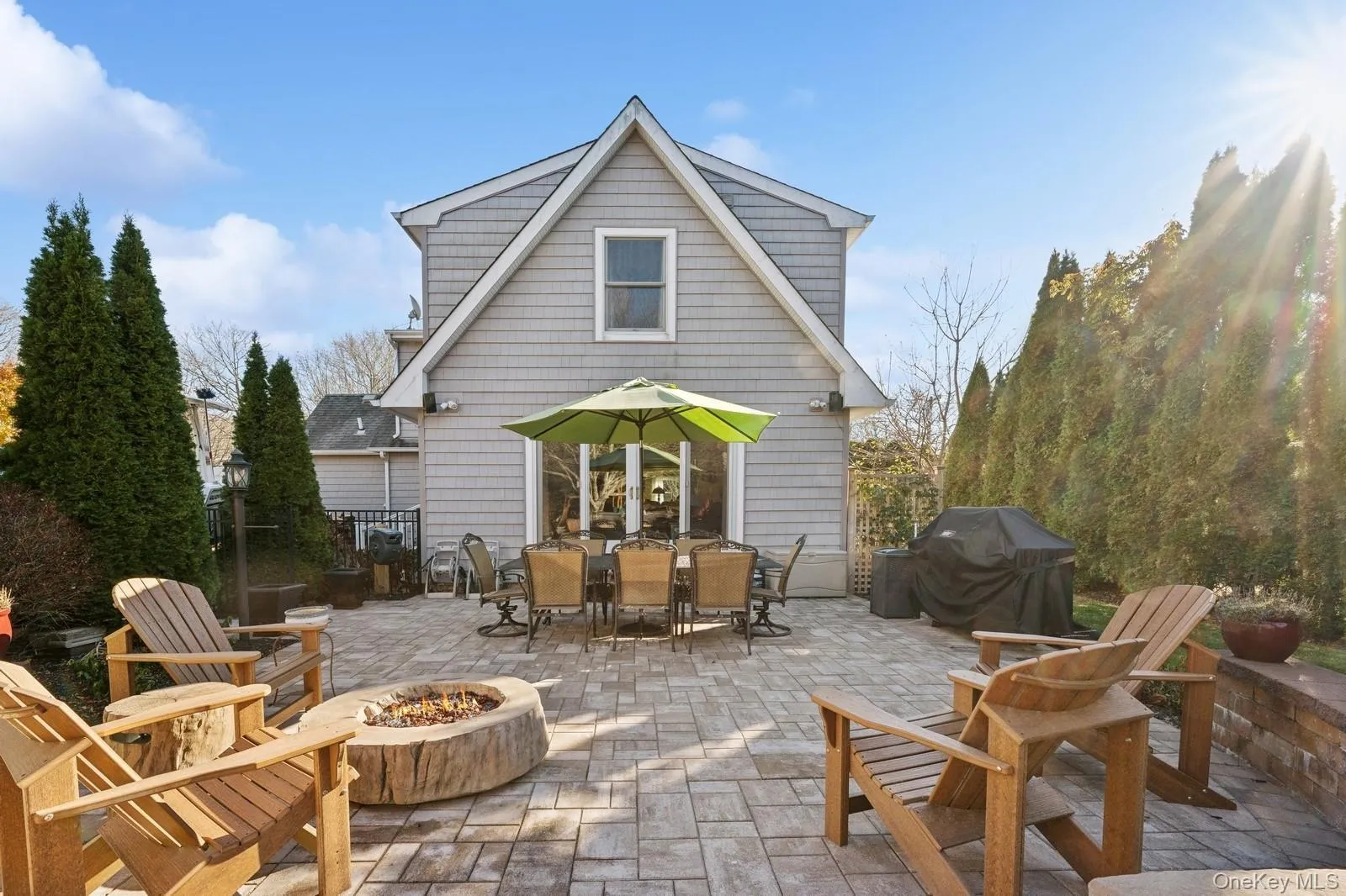 Rear view of house with an outdoor fire pit and a patio area Rear view of house with an outdoor fire pit and a patio area