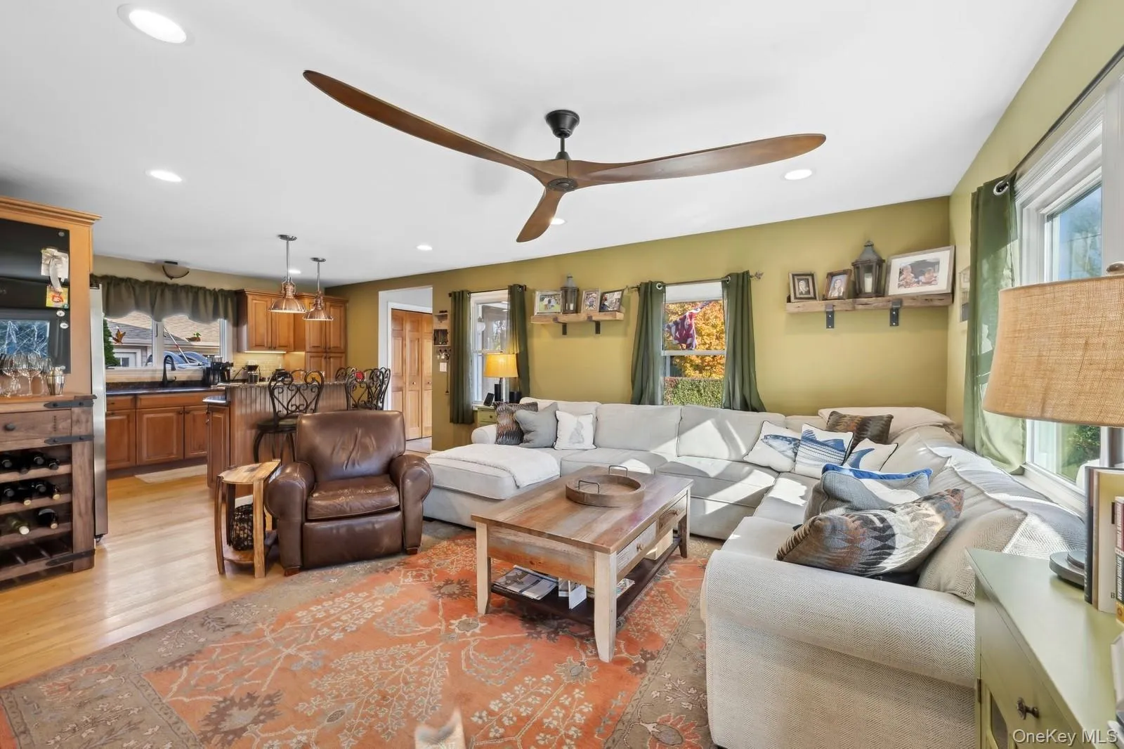 Living room featuring ceiling fan, light hardwood / wood-style flooring, and sink Living room featuring ceiling fan, light hardwood / wood-style flooring, and sink
