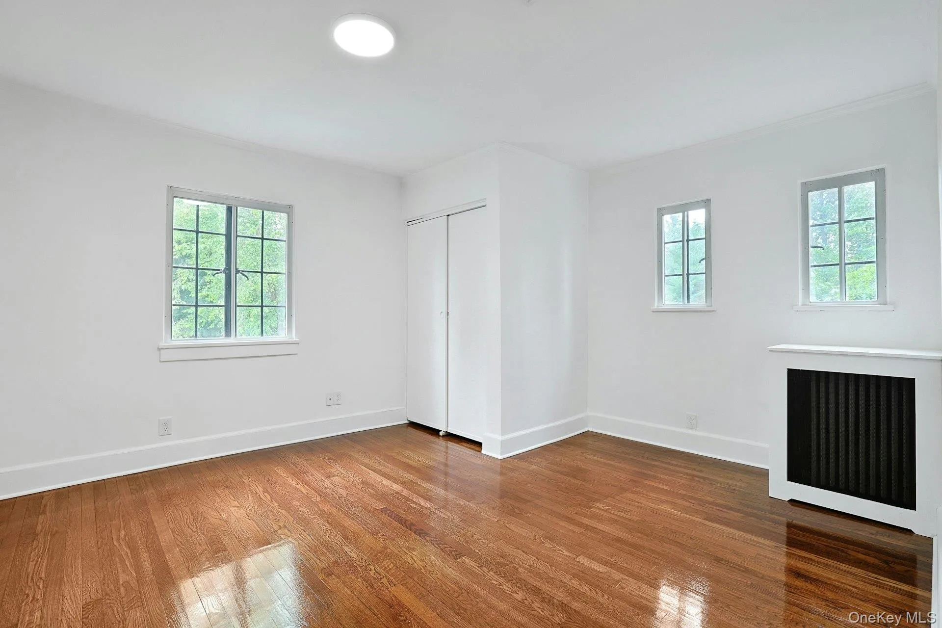 Filled with natural light, this generously sized bedroom offers classic Tudor-style windows, ample closet storage, and a fresh, airy ambiance. Filled with natural light, this generously sized bedroom offers classic Tudor-style windows, ample closet storage, and a fresh, airy ambiance.