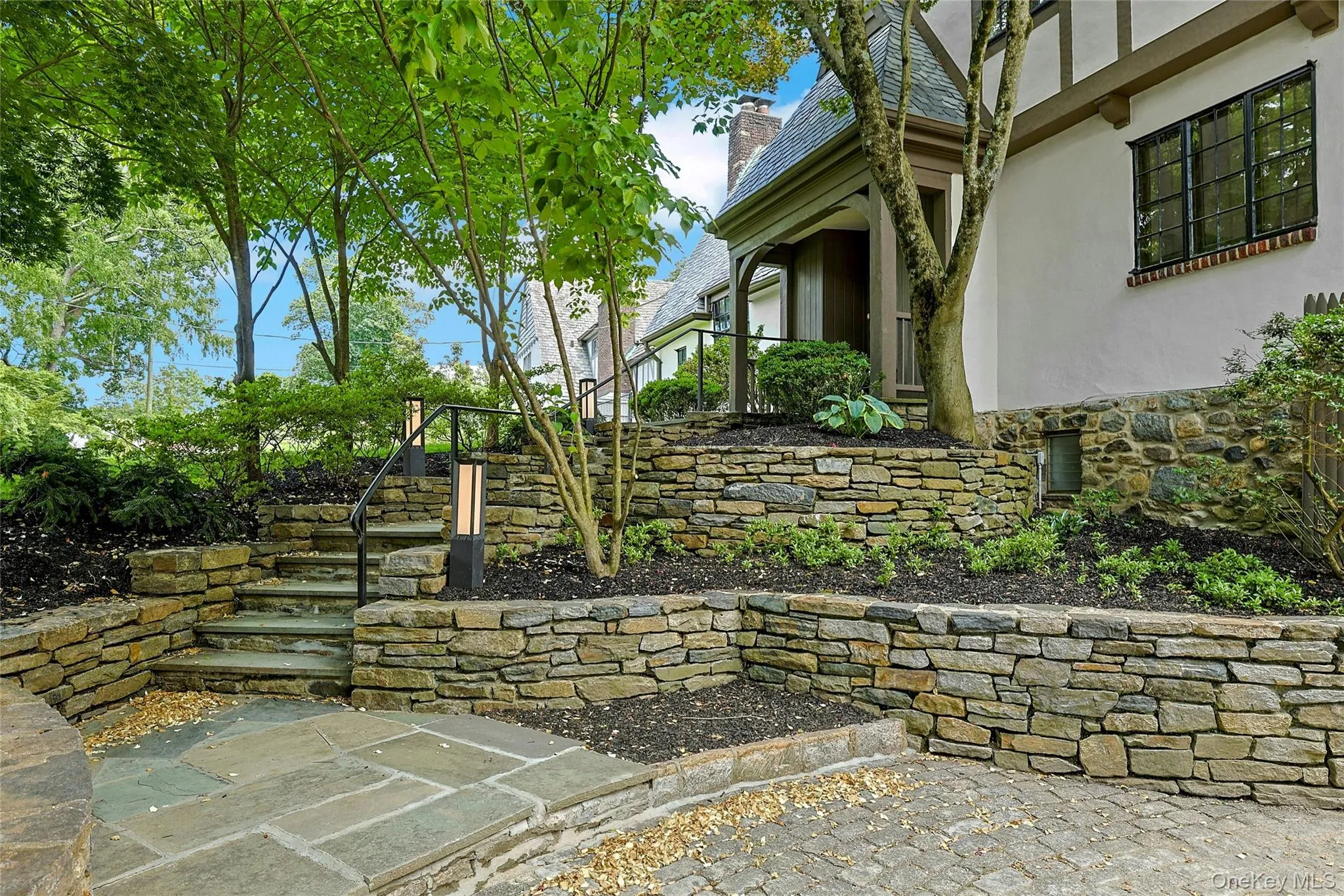 Extensive stacked stone masonry adorns the facade of this beautiful Tudor boasting a radiant heated driveway, steps and front path for winter safety and ease. Extensive stacked stone masonry adorns the facade of this beautiful Tudor boasting a radiant heated driveway, steps and front path for winter safety and ease.