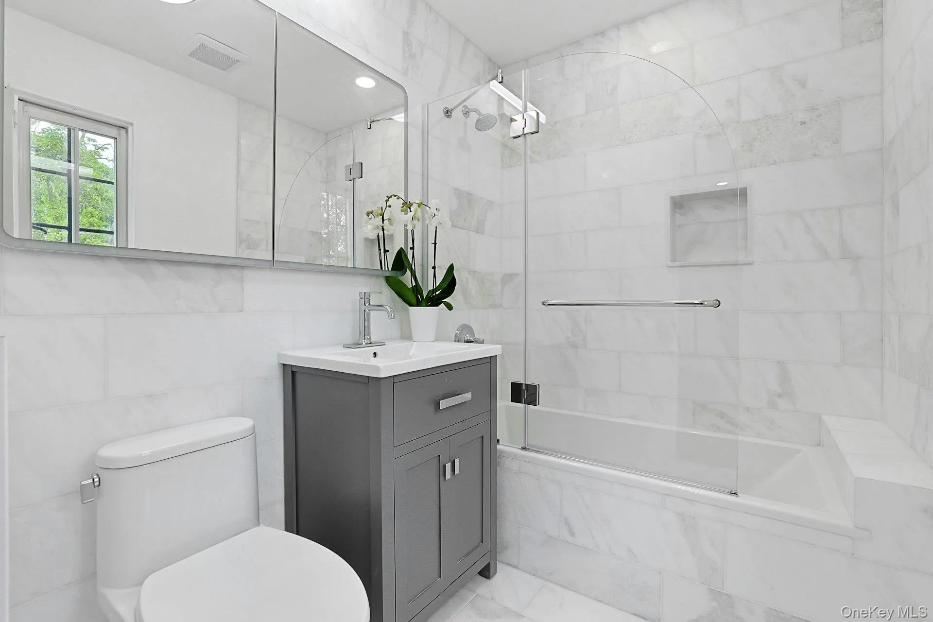 The beautifully renovated primary bath showcases timeless marble finishes, a sleek glass-enclosed tub and shower, and elegant contemporary fixtures, creating a spa-like retreat for everyday living. The beautifully renovated primary bath showcases timeless marble finishes, a sleek glass-enclosed tub and shower, and elegant contemporary fixtures, creating a spa-like retreat for everyday living.