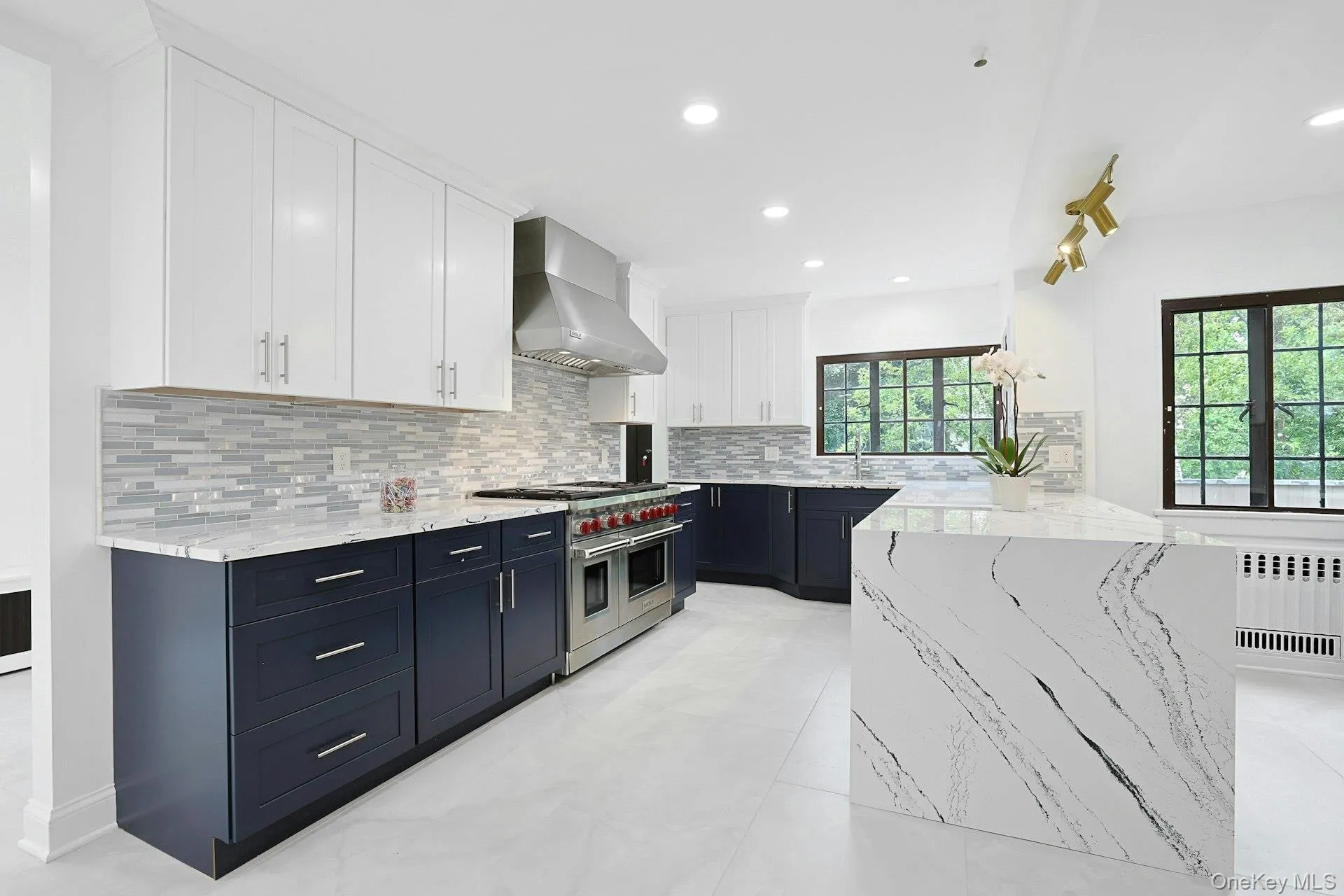 The stunning chef's kitchen has been completely renovated with quartz countertops, custom cabinetry, and premium appliances, including a Wolf six-burner range with griddle and double ovens. The stunning chef's kitchen has been completely renovated with quartz countertops, custom cabinetry, and premium appliances, including a Wolf six-burner range with griddle and double ovens.