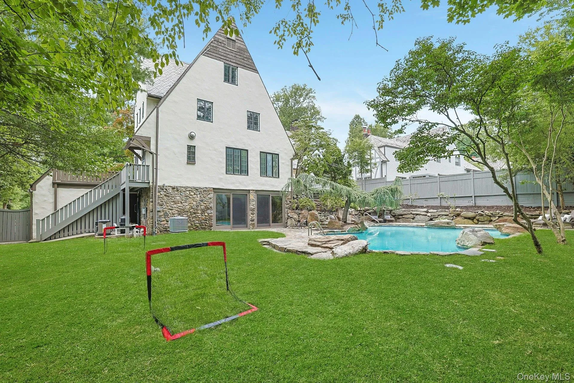 Framed by mature trees and lush greenery, the spacious and usable backyard offers the perfect balance of active play space and resort-inspired outdoor living. Framed by mature trees and lush greenery, the spacious and usable backyard offers the perfect balance of active play space and resort-inspired outdoor living.