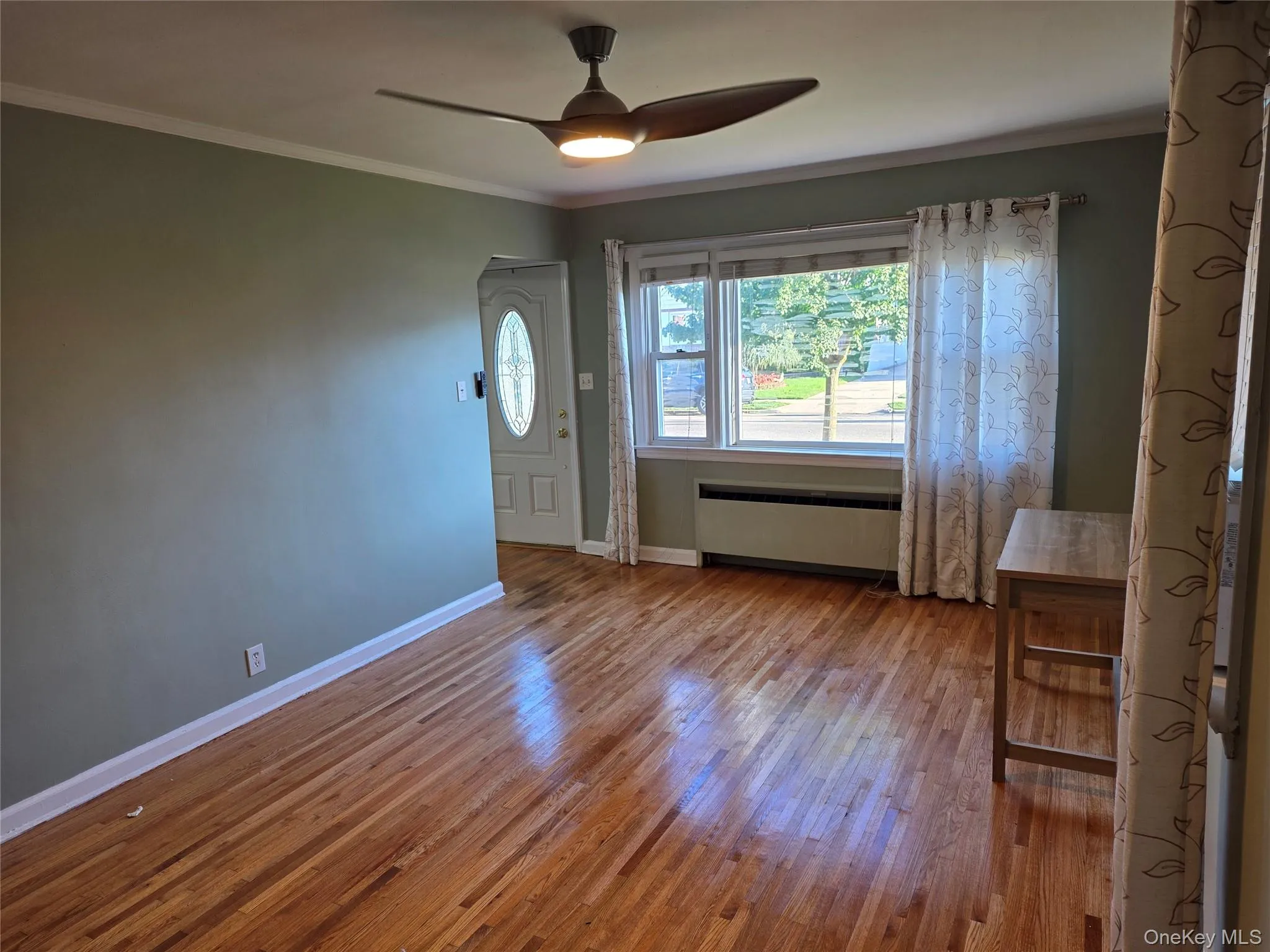 Entryway featuring ornamental molding, hardwood / wood-style floors, and a ceiling fan Entryway featuring ornamental molding, hardwood / wood-style floors, and a ceiling fan