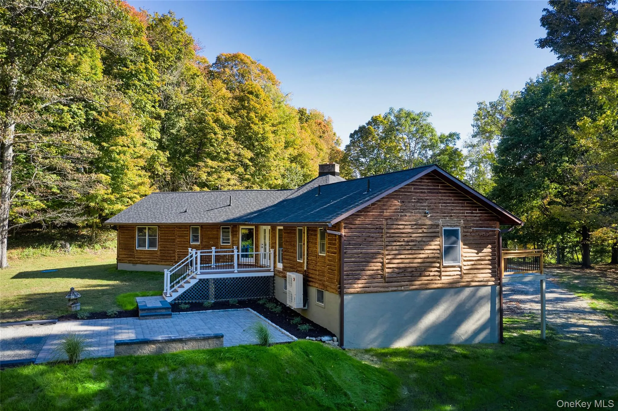 Rustic home featuring a front lawn, a chimney, and a deck Rustic home featuring a front lawn, a chimney, and a deck