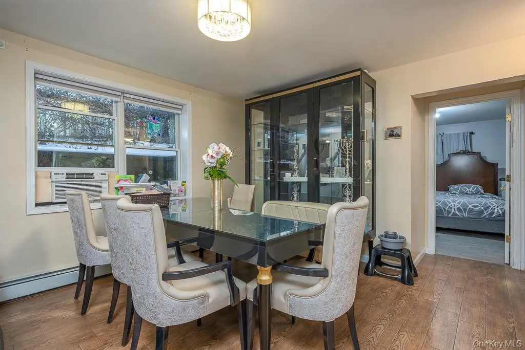 Dining area featuring french doors, wood-type flooring, a baseboard radiator, and cooling unit Dining area featuring french doors, wood-type flooring, a baseboard radiator, and cooling unit