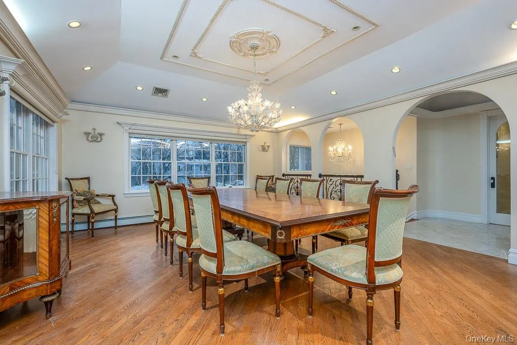 Dining space featuring ornamental molding, wood finished floors, arched walkways, a chandelier, and recessed lighting Dining space featuring ornamental molding, wood finished floors, arched walkways, a chandelier, and recessed lighting