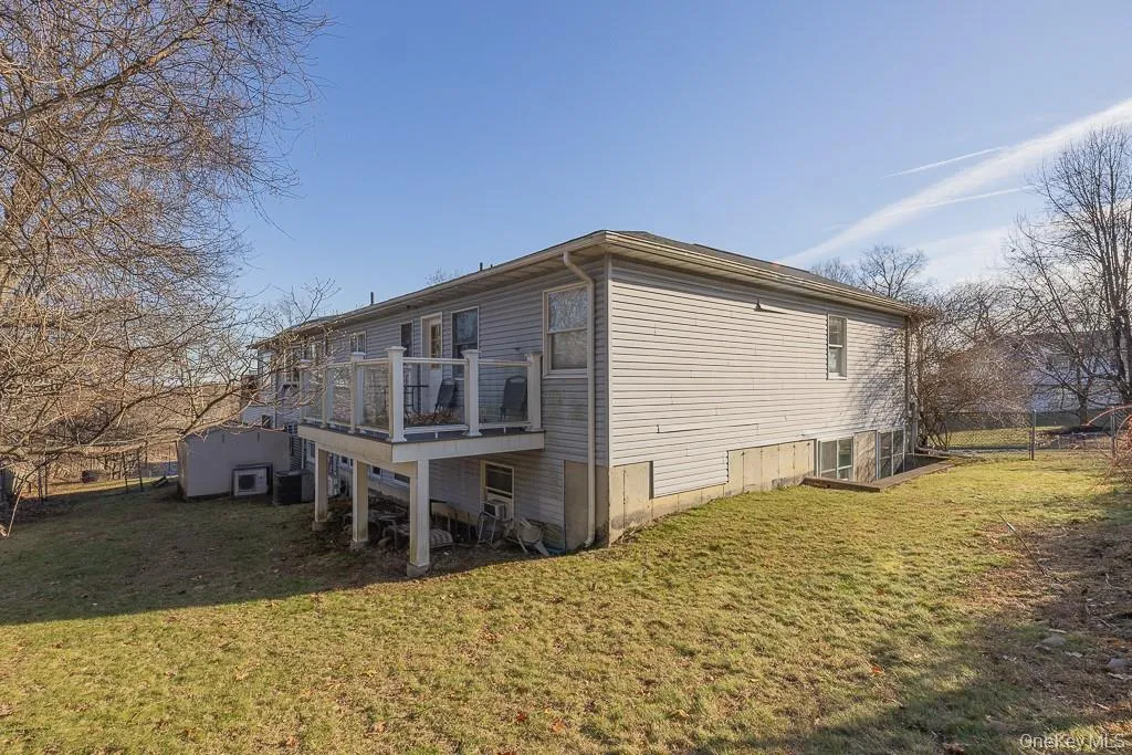 Rear view of house with a yard and a deck Rear view of house with a yard and a deck