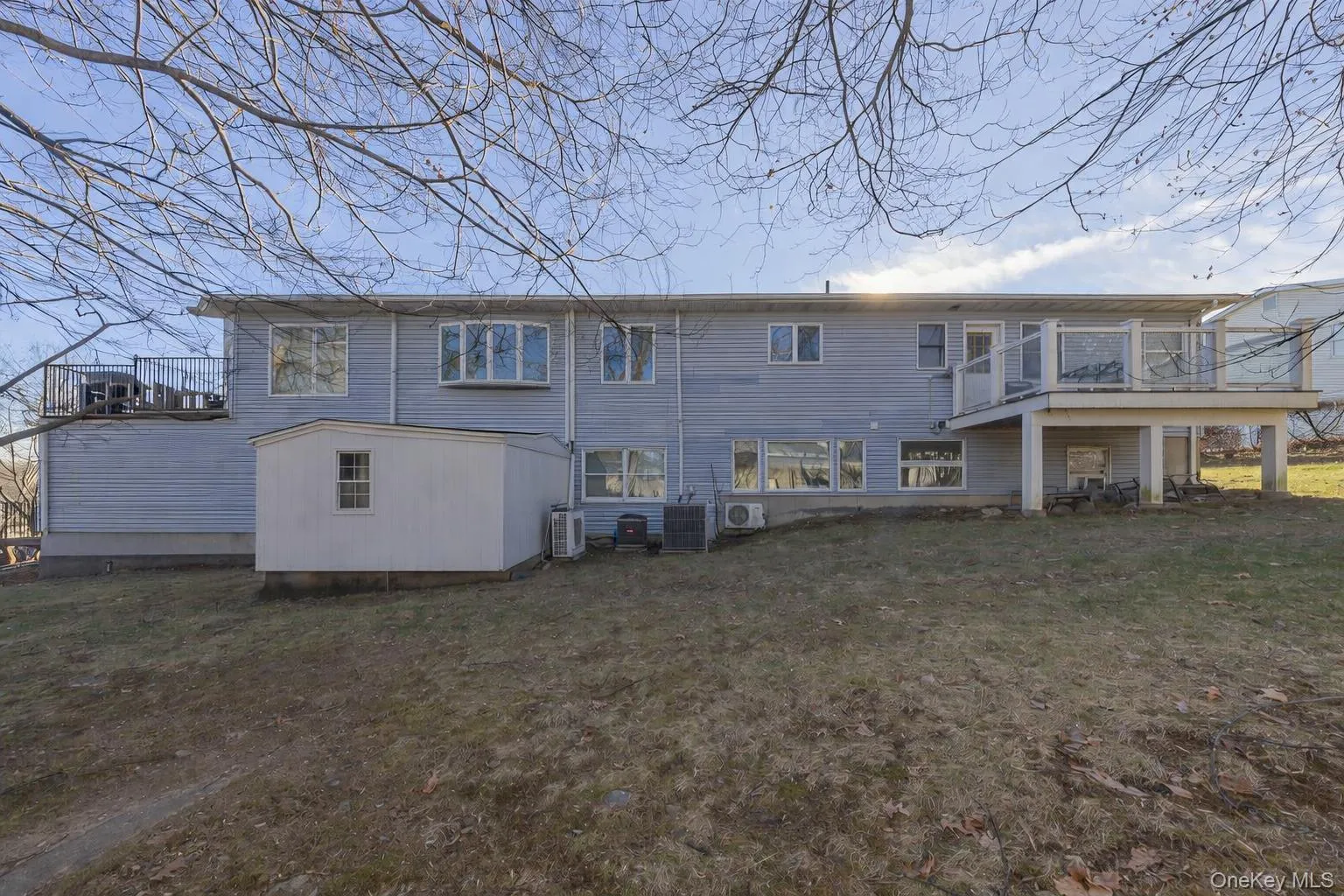 Back of house featuring a deck and a lawn Back of house featuring a deck and a lawn