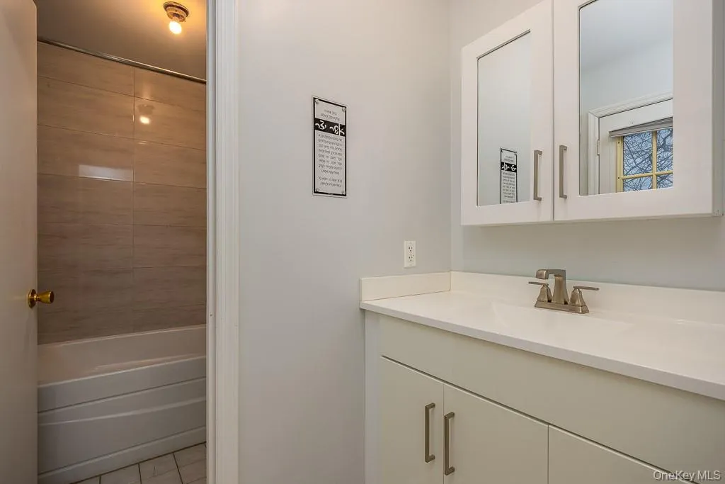 Bathroom with vanity, shower / tub combination, and light tile patterned floors Bathroom with vanity, shower / tub combination, and light tile patterned floors