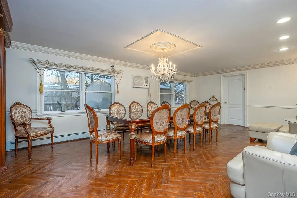 Dining room with a baseboard radiator, a chandelier, recessed lighting, crown molding, and an AC wall unit Dining room with a baseboard radiator, a chandelier, recessed lighting, crown molding, and an AC wall unit