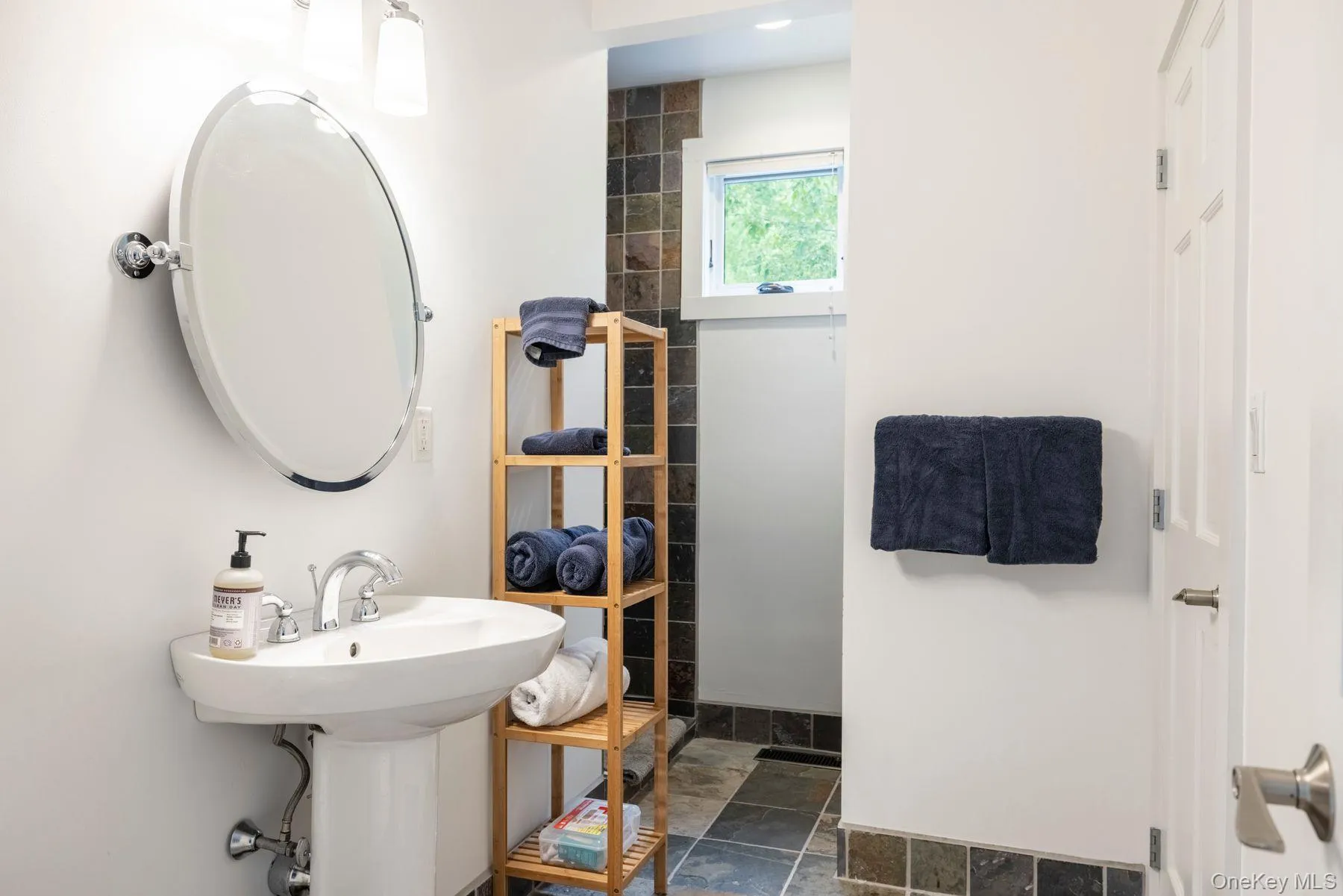 Full bath with stone finish floors and a shower Full bath with stone finish floors and a shower
