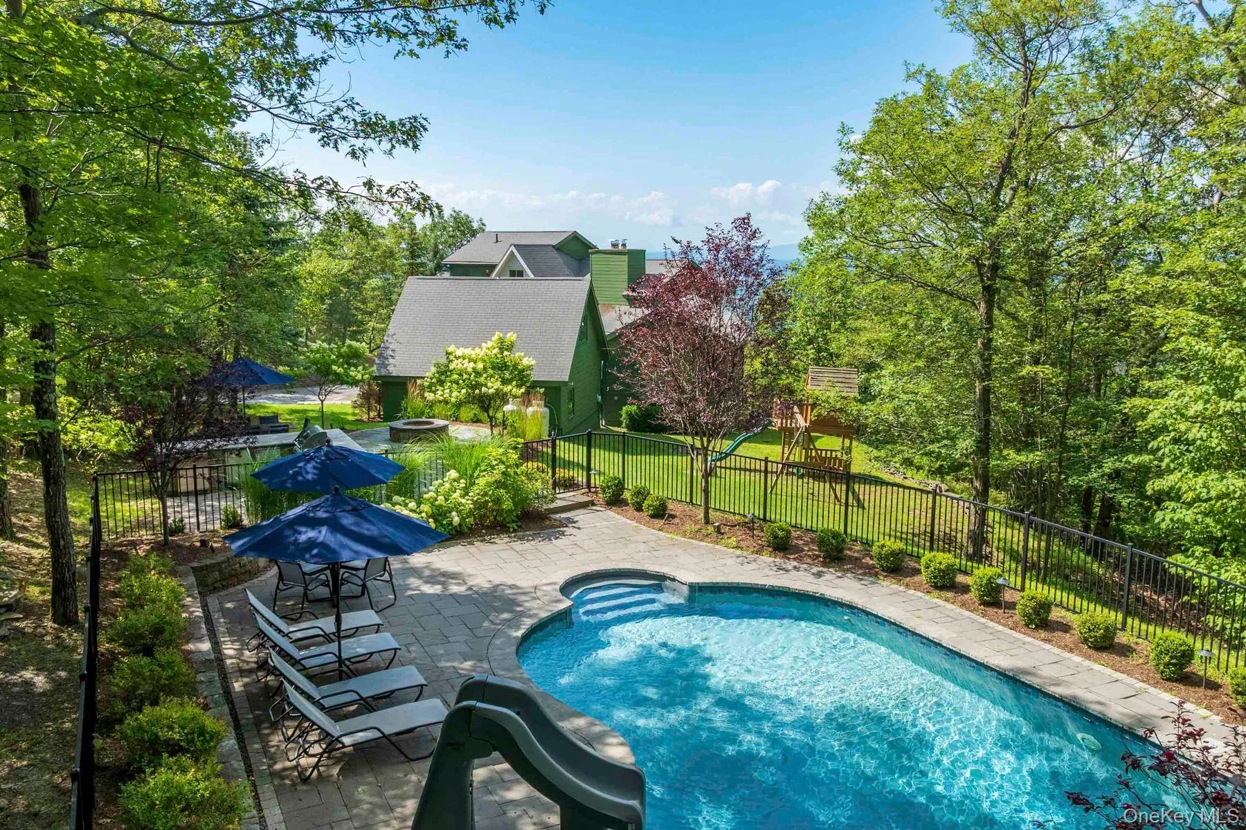 View of fenced swimming pool, outdoor kitchen and fire pit. View of fenced swimming pool, outdoor kitchen and fire pit.
