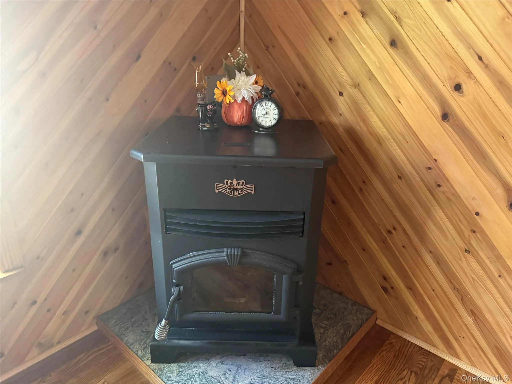Detailed view of wood finished floors, wood walls, and a wood stove Detailed view of wood finished floors, wood walls, and a wood stove