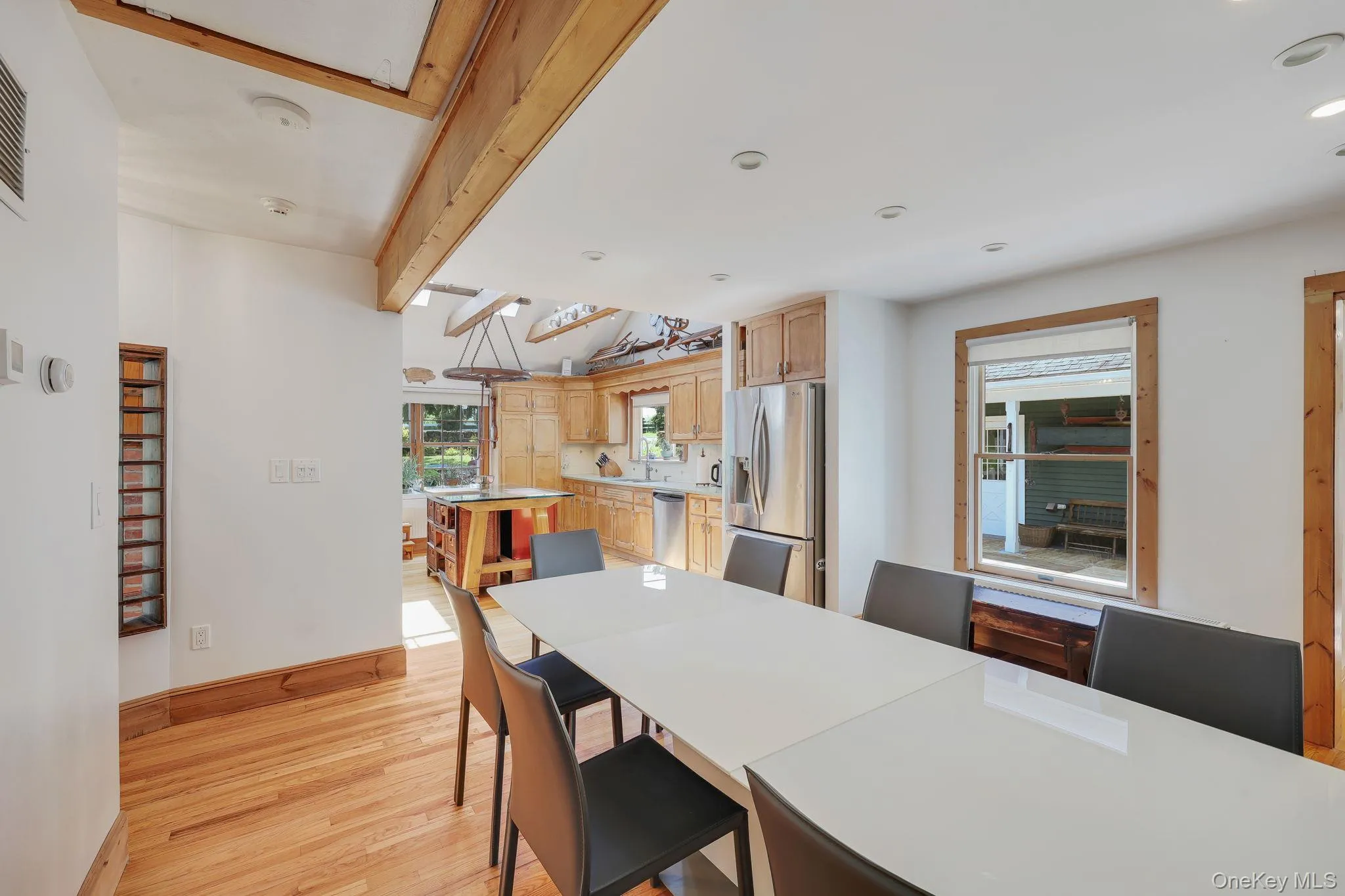 Open-concept dining and kitchen areas with hard wood flooring, exposed ceiling beams and recessed lighting. Open-concept dining and kitchen areas with hard wood flooring, exposed ceiling beams and recessed lighting.