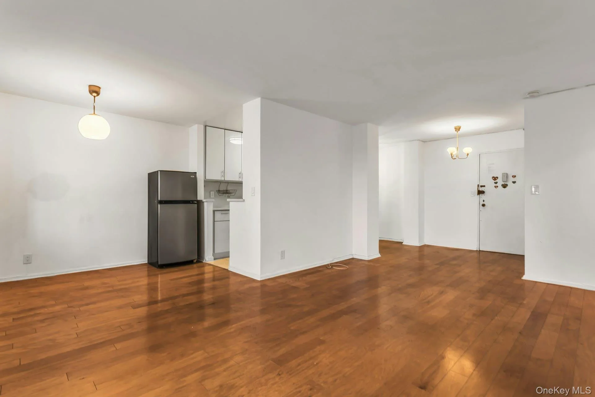 Unfurnished living room featuring hardwood / wood-style floors and a chandelier Unfurnished living room featuring hardwood / wood-style floors and a chandelier
